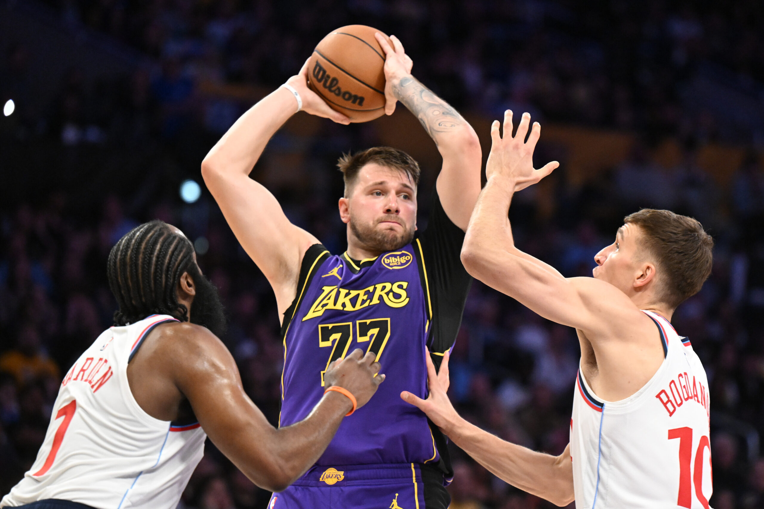 Lakers star Luka Doncic looks to pass while being double-teamed...