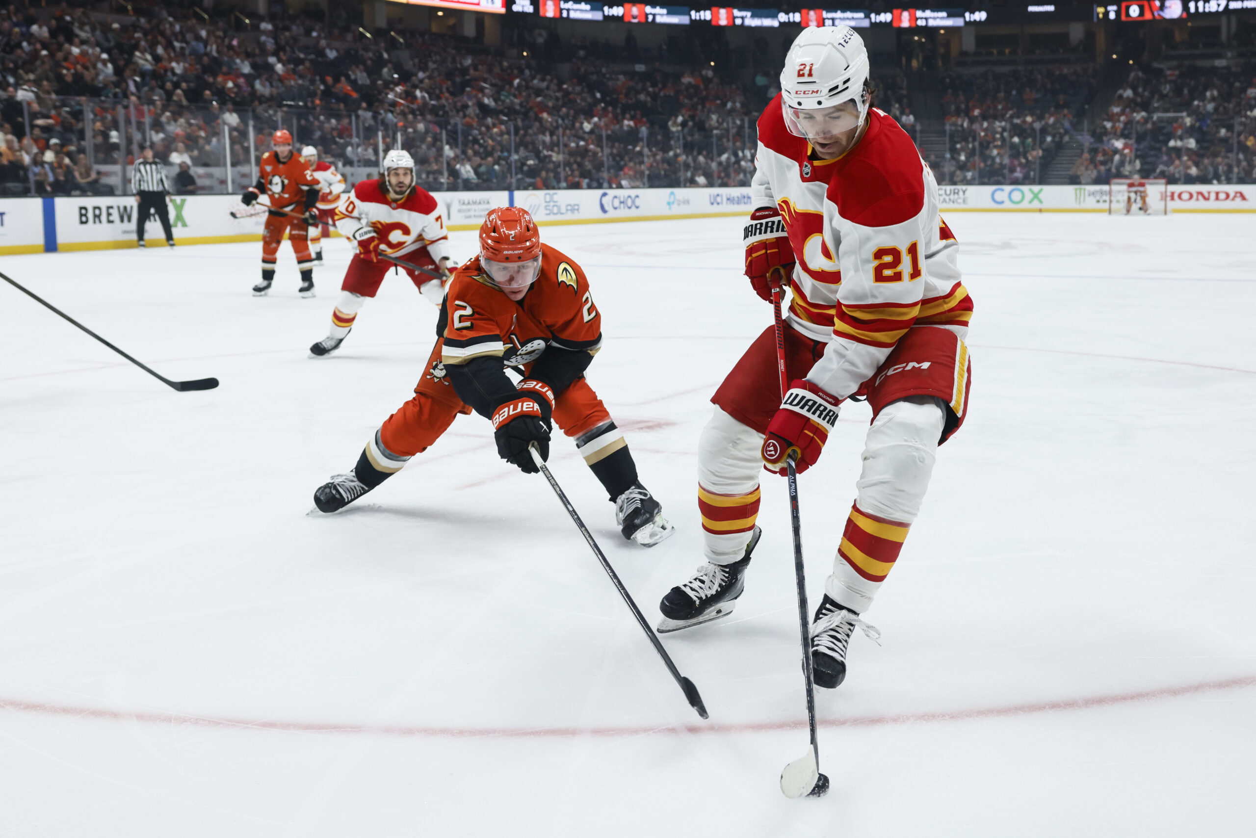 Calgary Flames center Kevin Rooney, right, controls the puck away...