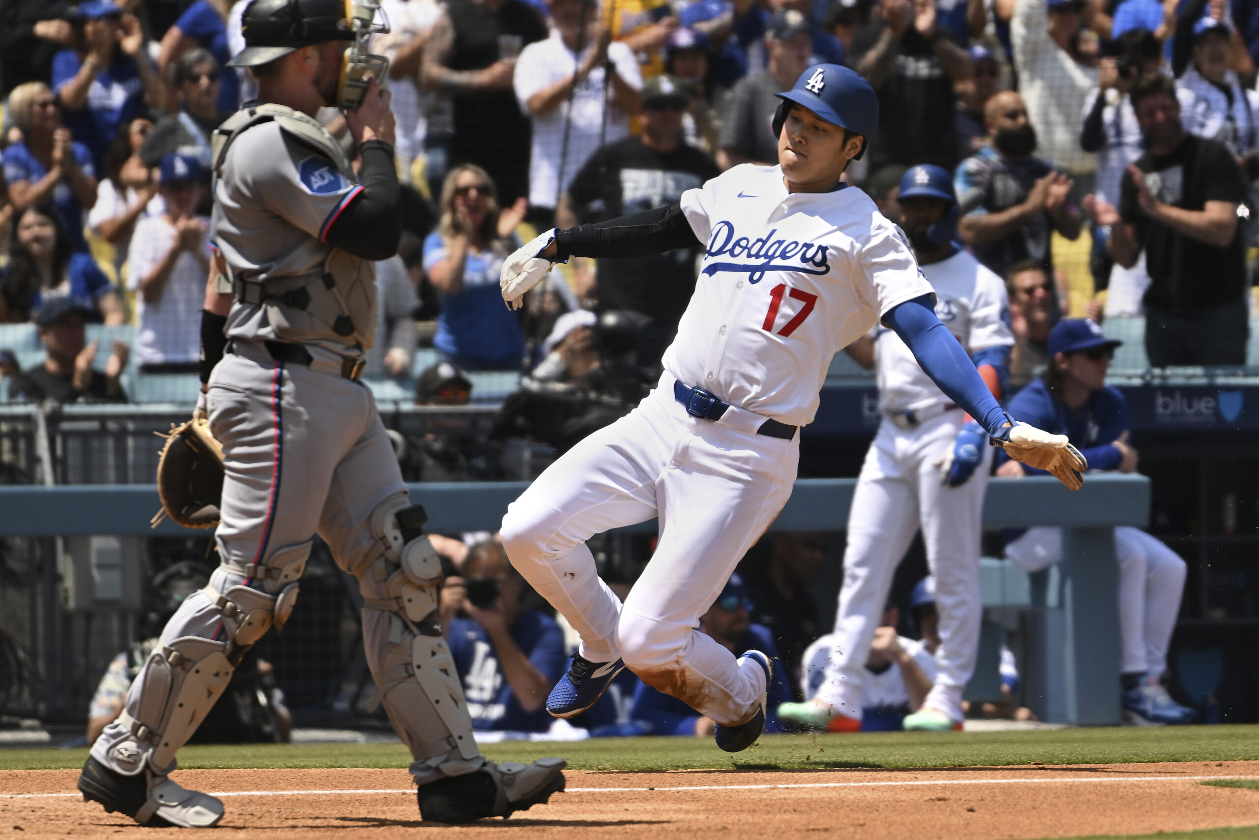 Dodgers star Shohei Ohtani slides home to score a run...