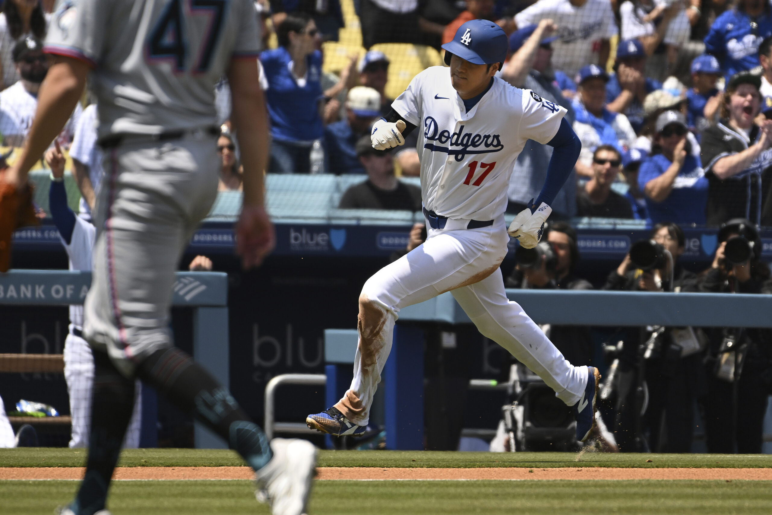 Dodgers star Shohei Ohtani rounds third base to score a...