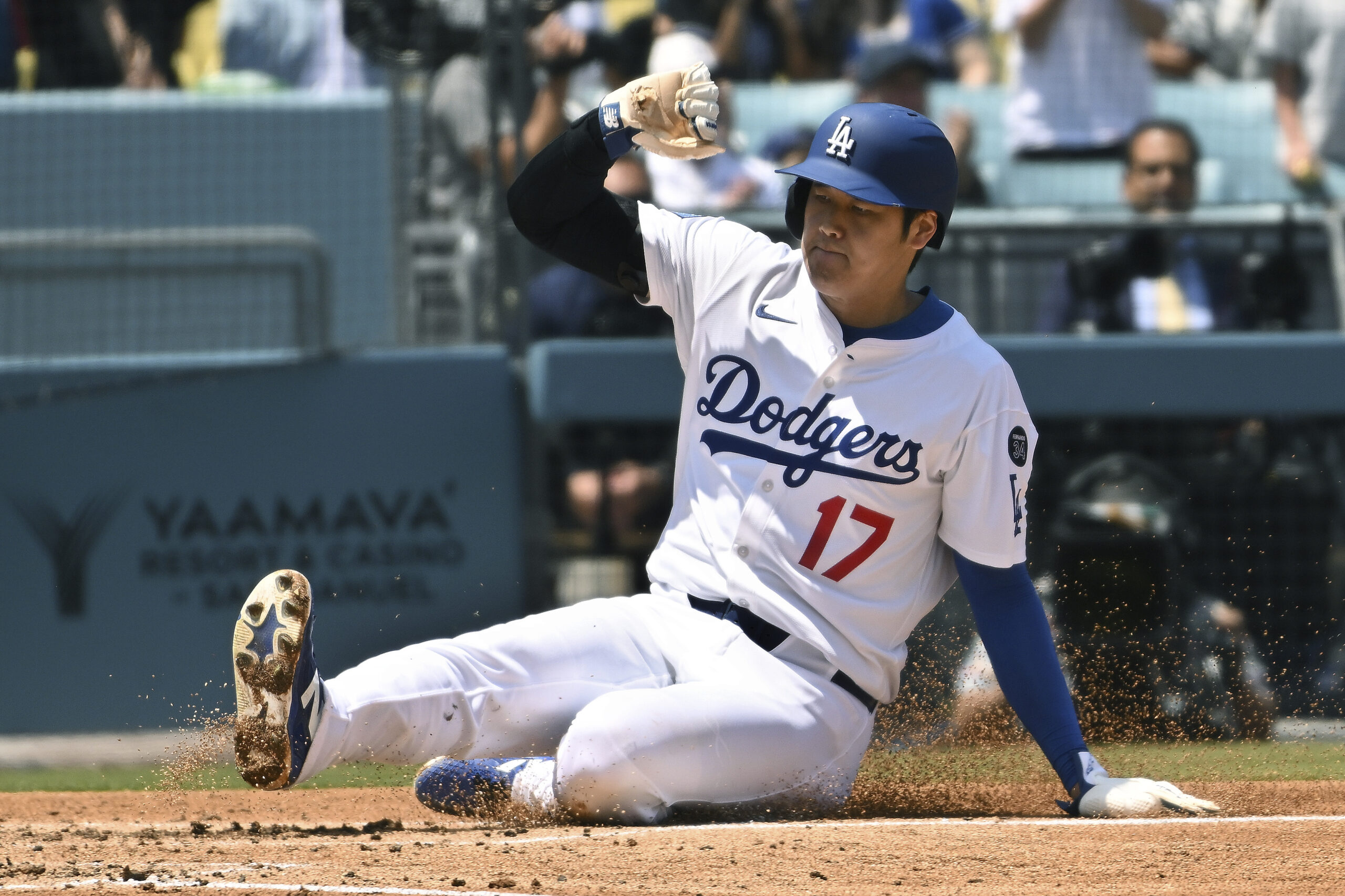 Dodgers star Shohei Ohtani slides home to score a run...