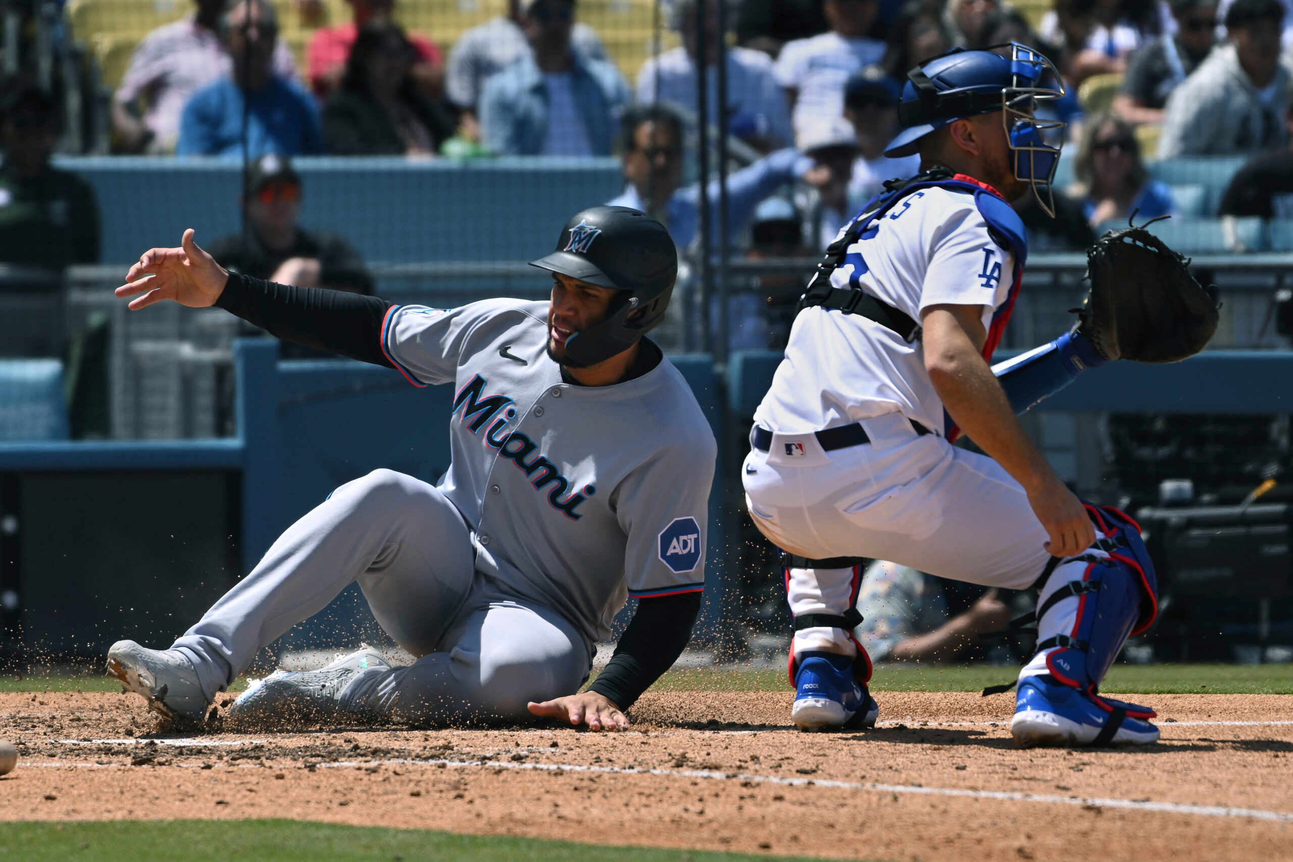 The Miami Marlins’ Agustín Ramírez, left, slides home safely as...