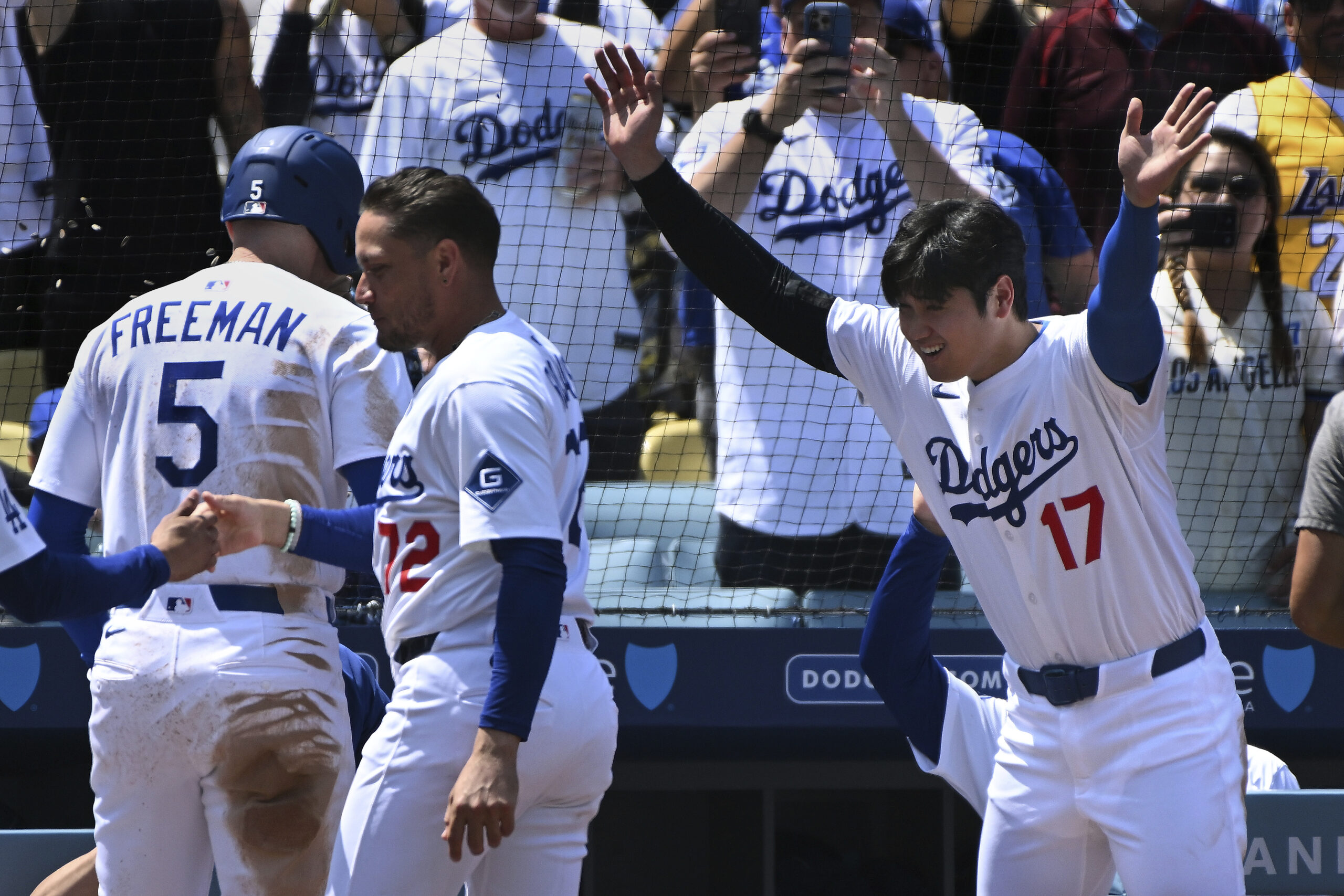 The Dodgers’ Freddie Freeman (5) is greeted by teammate Shohei...
