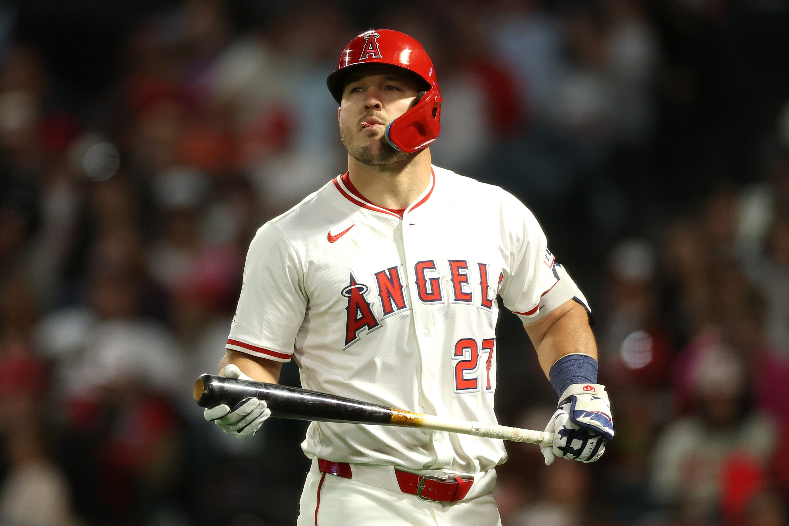 Angels star Mike Trout reacts as he walks back to...