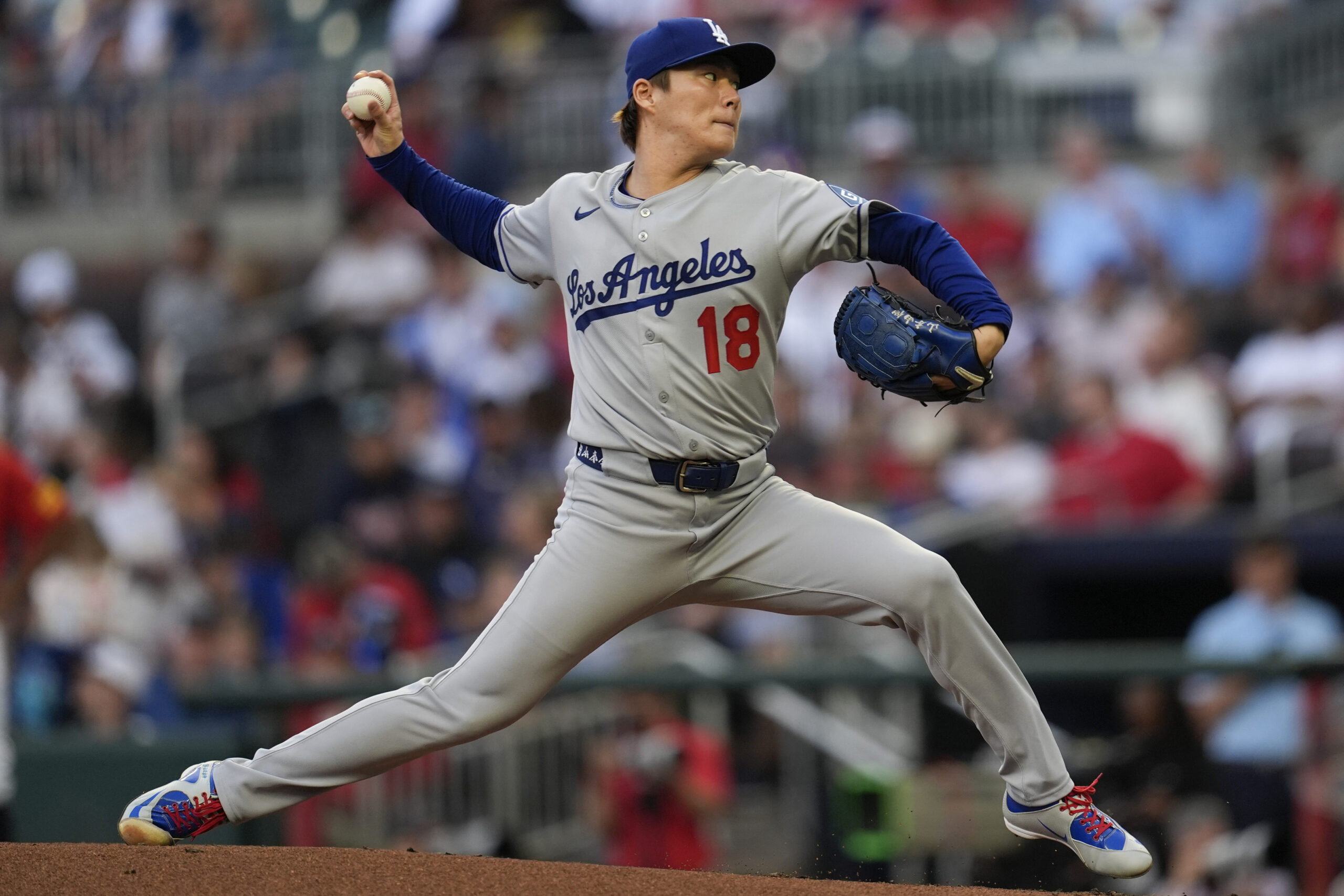 Dodgers starting pitcher Yoshinobu Yamamoto throws to the plate during...