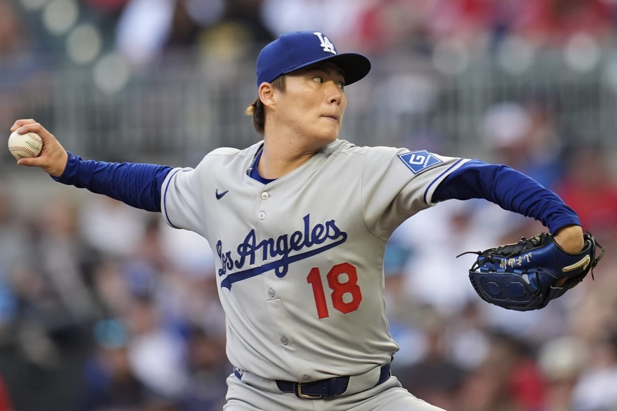 Dodgers starting pitcher Yoshinobu Yamamoto throws to the plate during...