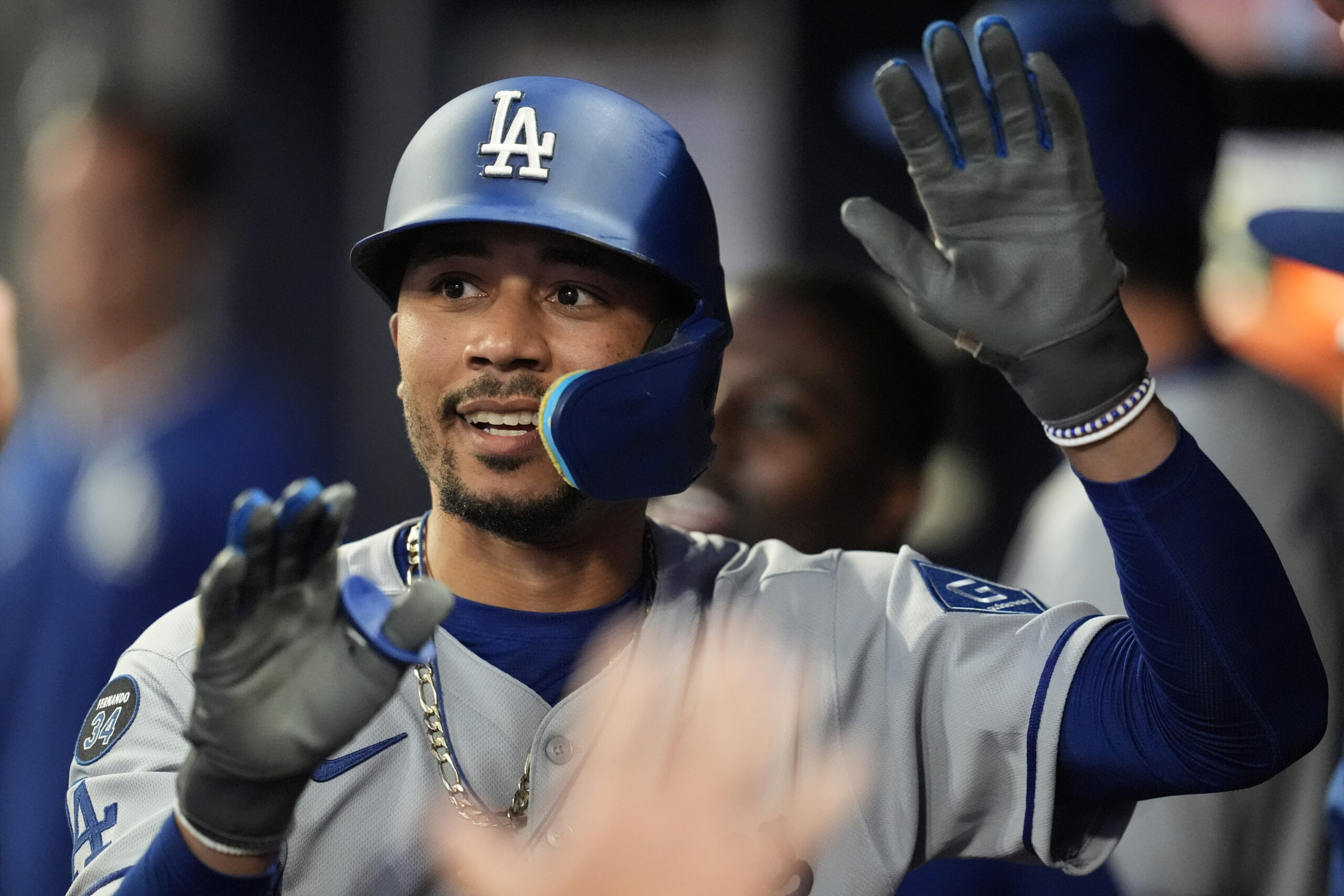 Dodgers star Mookie Betts celebrates in the dugout after hitting...