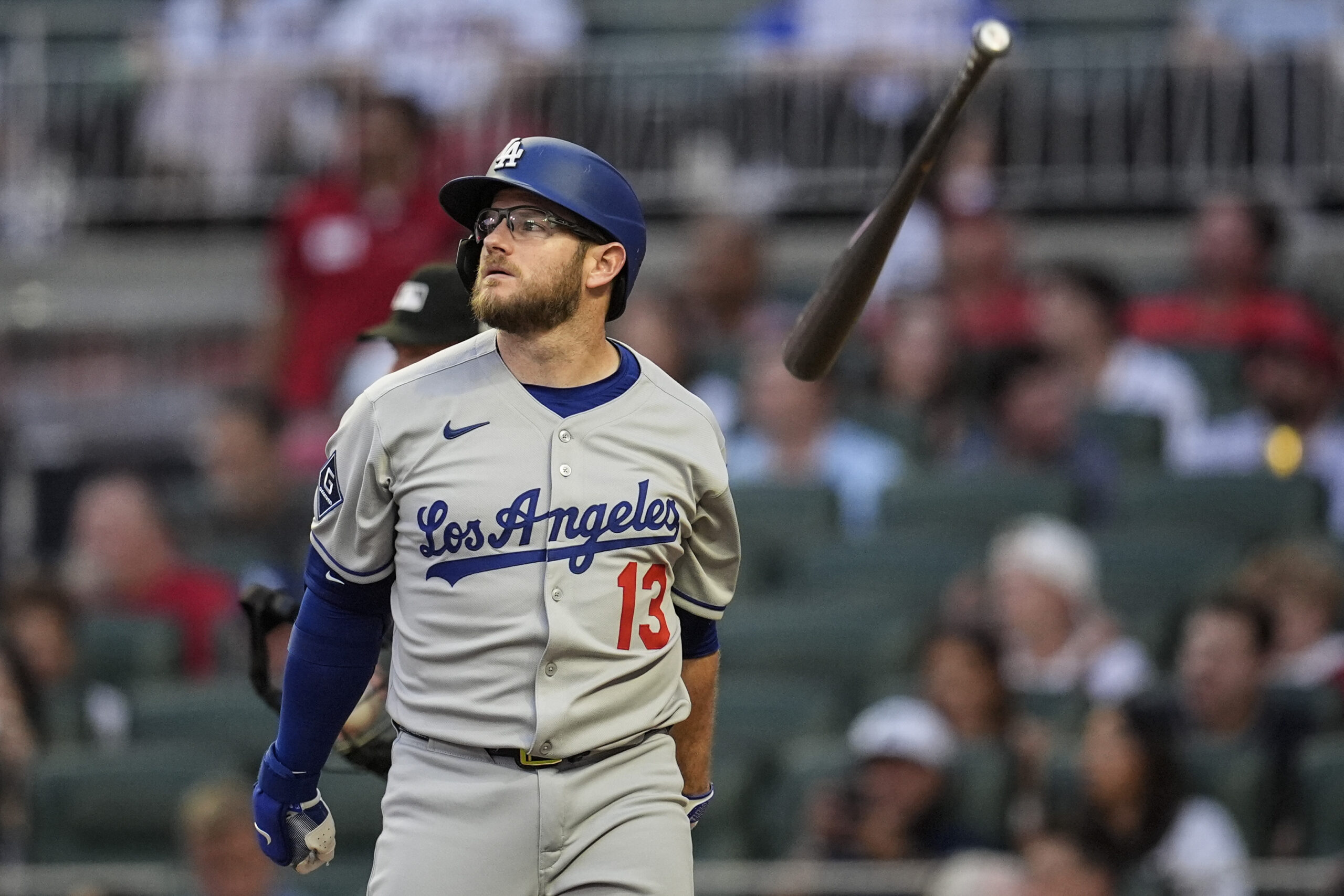 The Dodgers’ Max Muncy tosses his bat in the air...