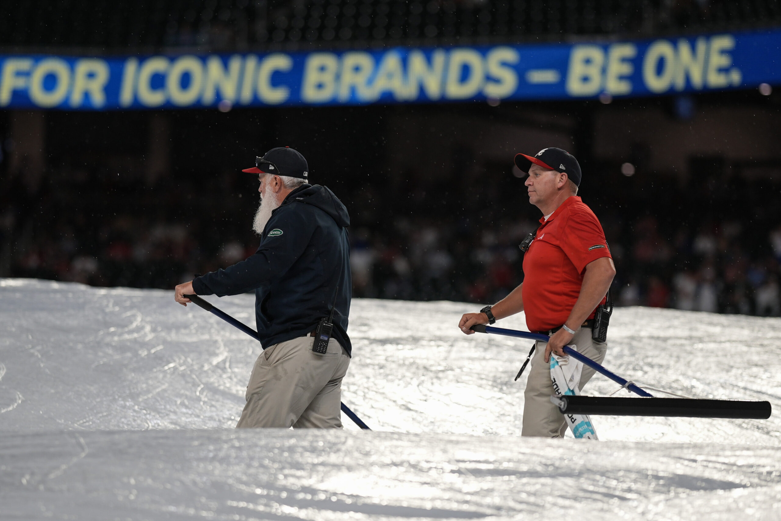 Grounds crew work during a rain delay in the ninth...