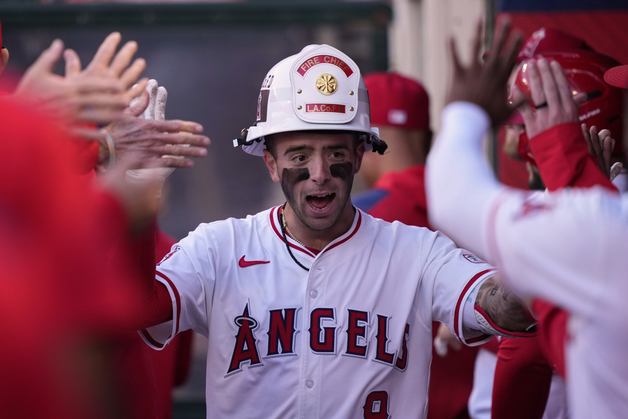 The Angels’ Zach Neto is congratulated by teammates in the...