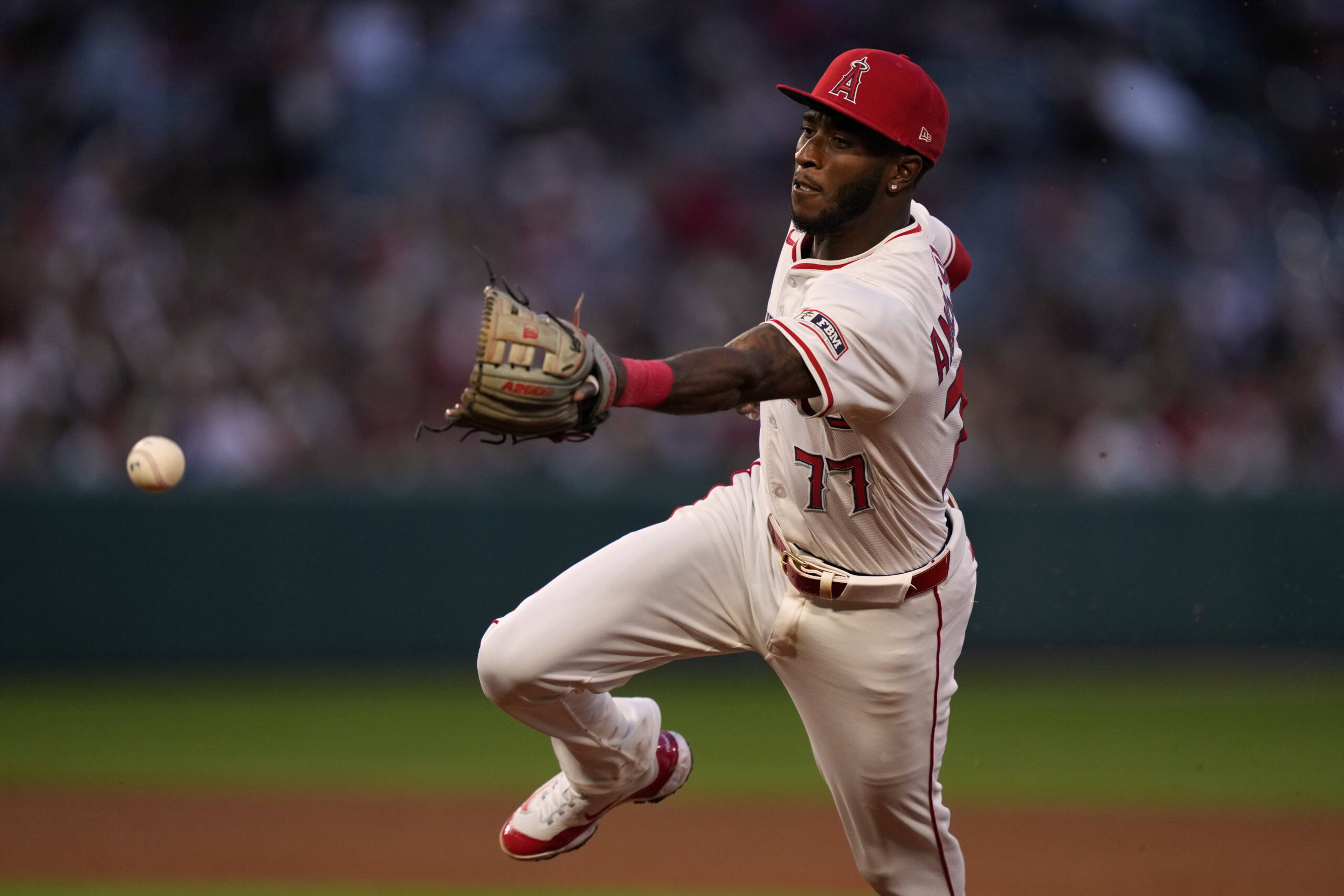 Angels second baseman Tim Anderson overthrows the ball to first,...