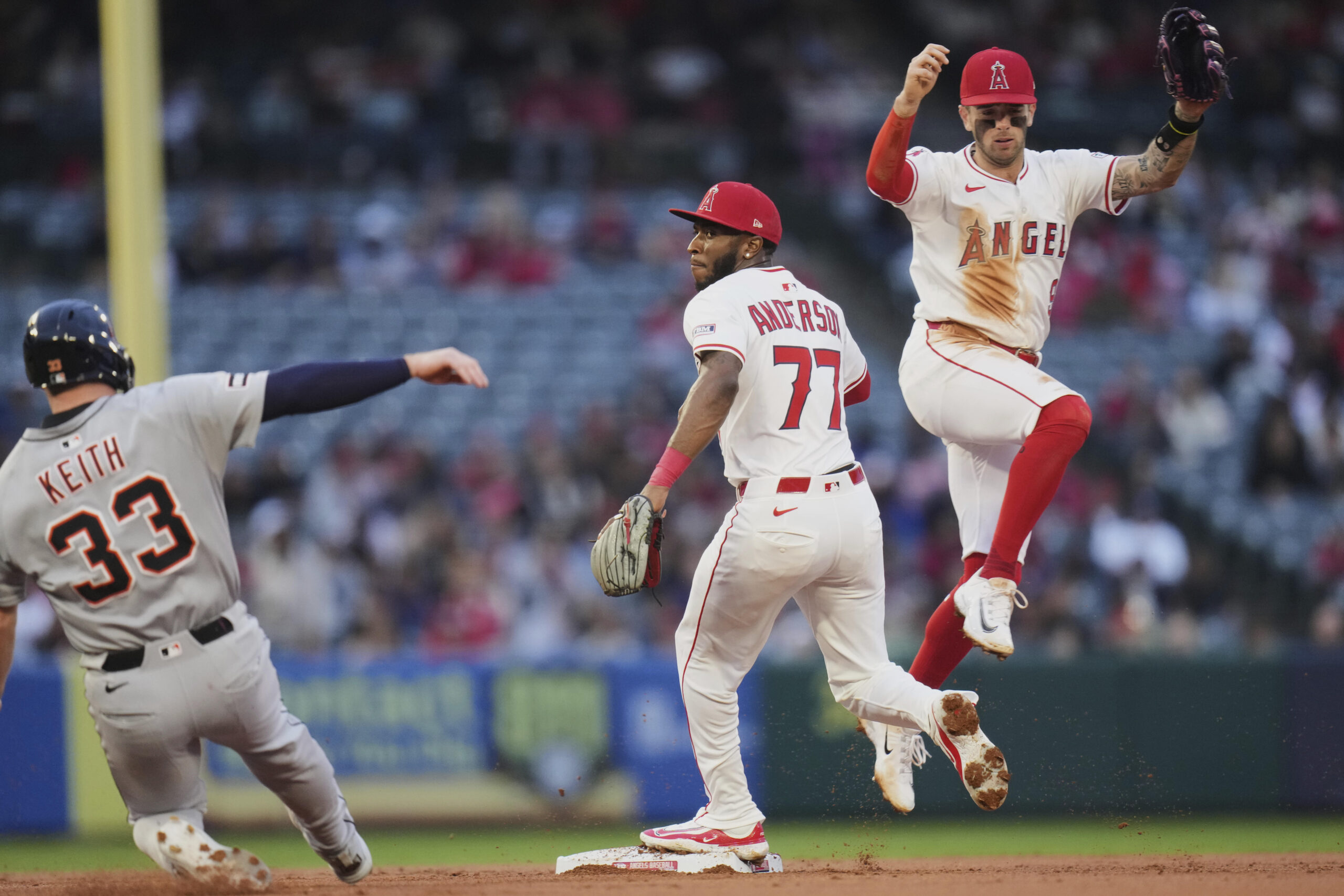 Angels shortstop Zach Neto, right, leaps as second baseman Tim...