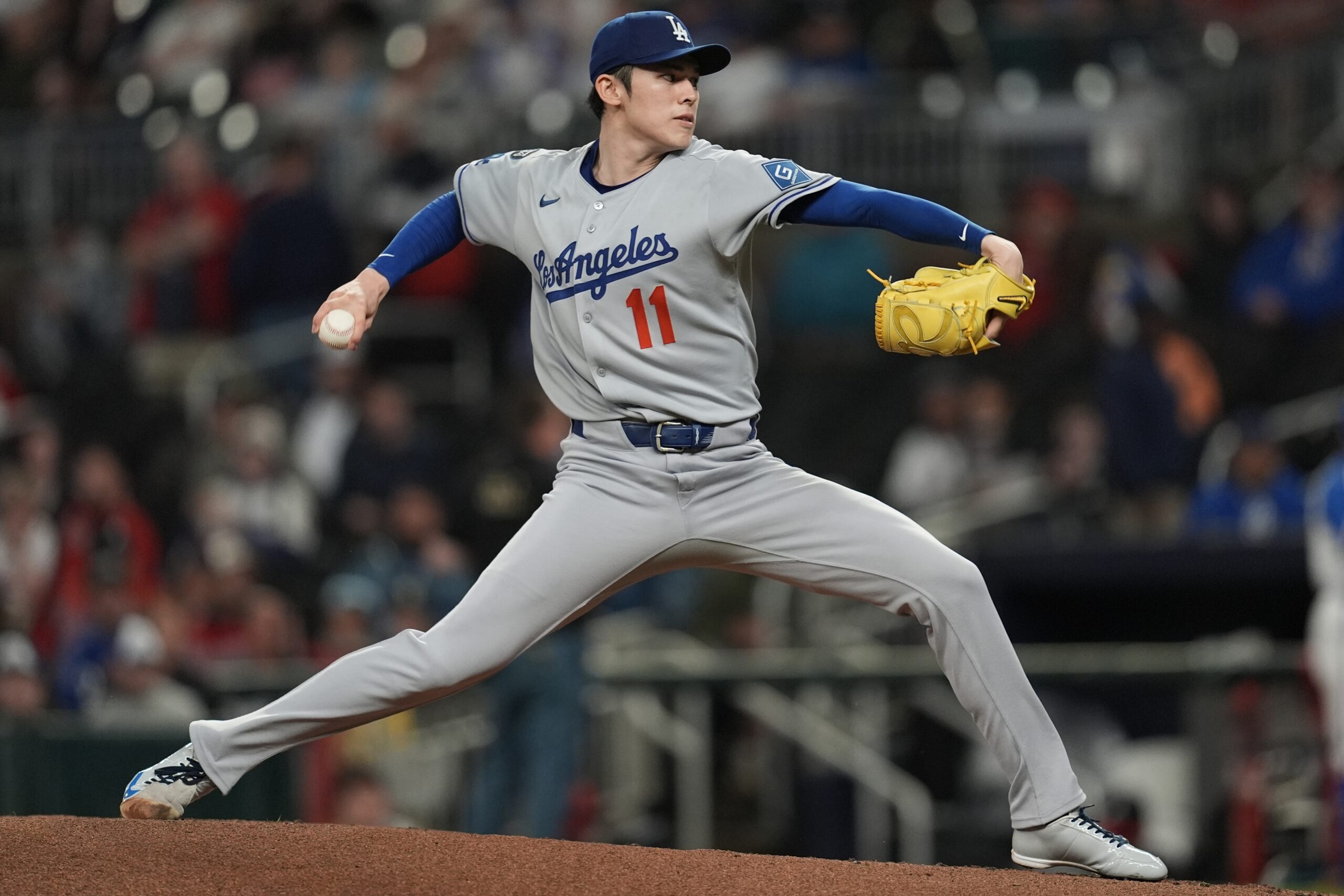 Dodgers starting pitcher Roki Sasaki throws to the plate against...