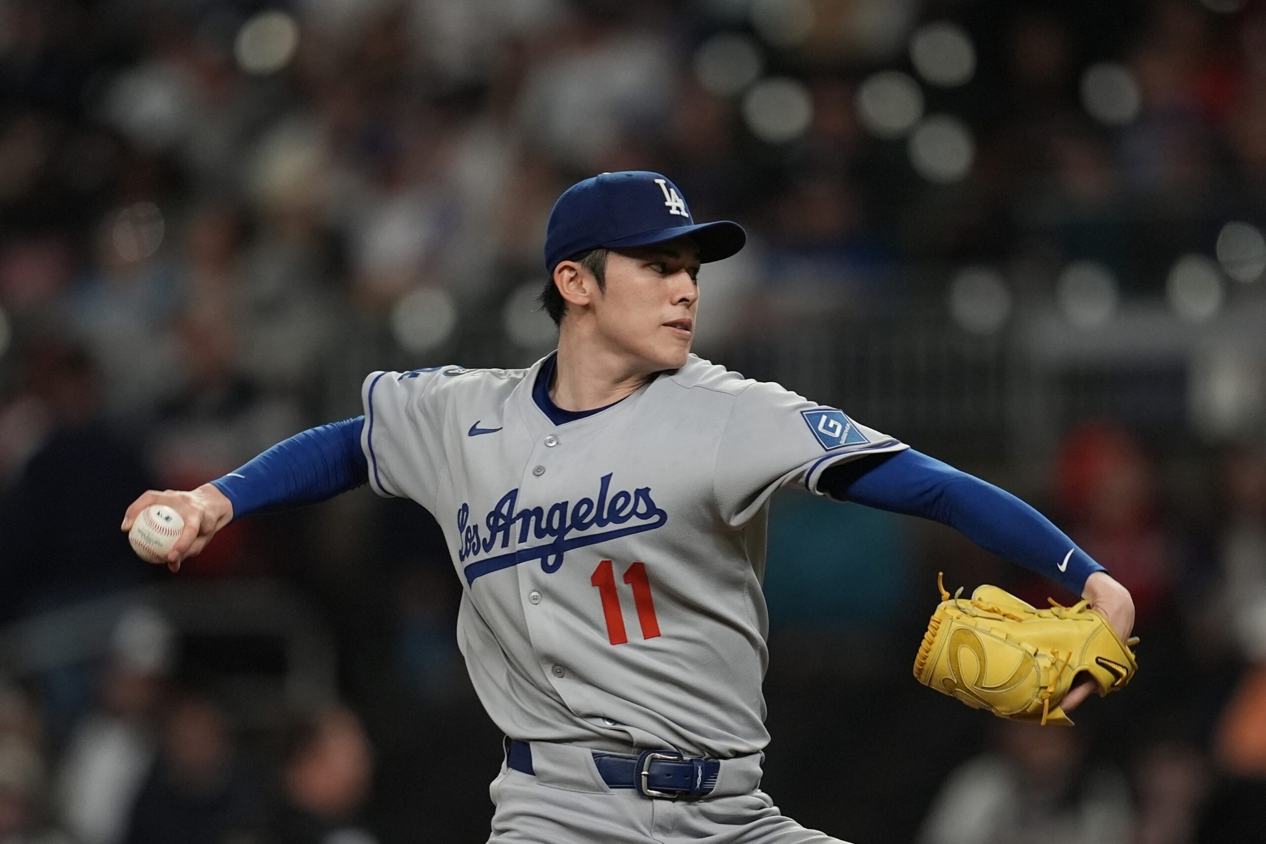 Dodgers starting pitcher Roki Sasaki throws to the plate against...