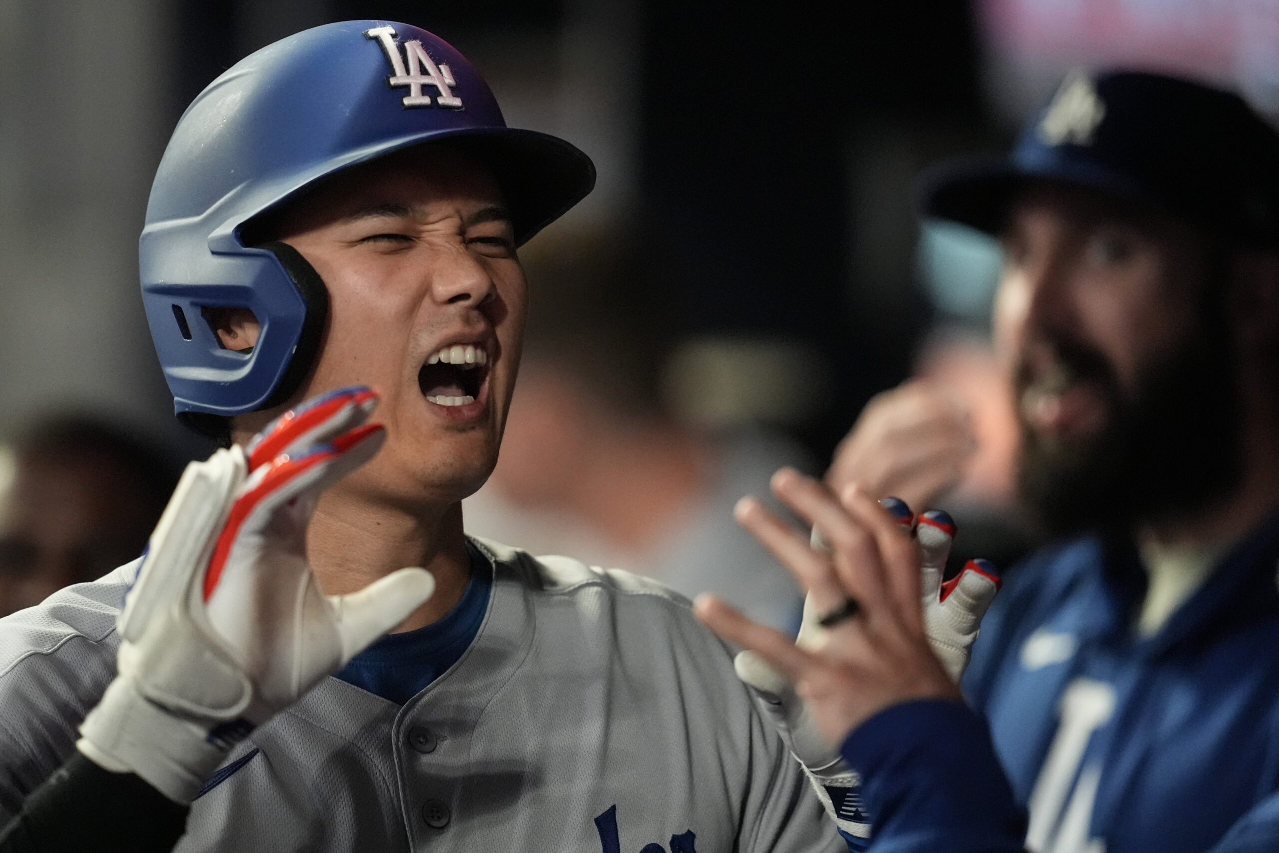 Dodgers star Shohei Ohtani celebrates in the dugout after hitting...