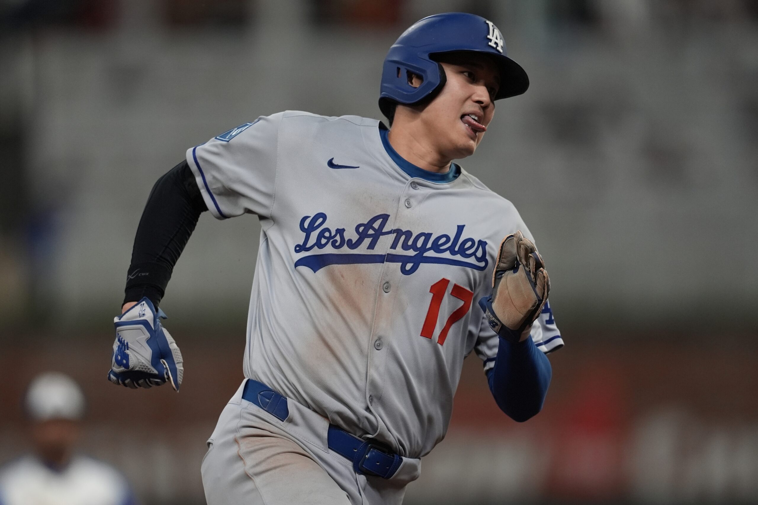 Dodgers star Shohei Ohtani runs the bases after a hit...