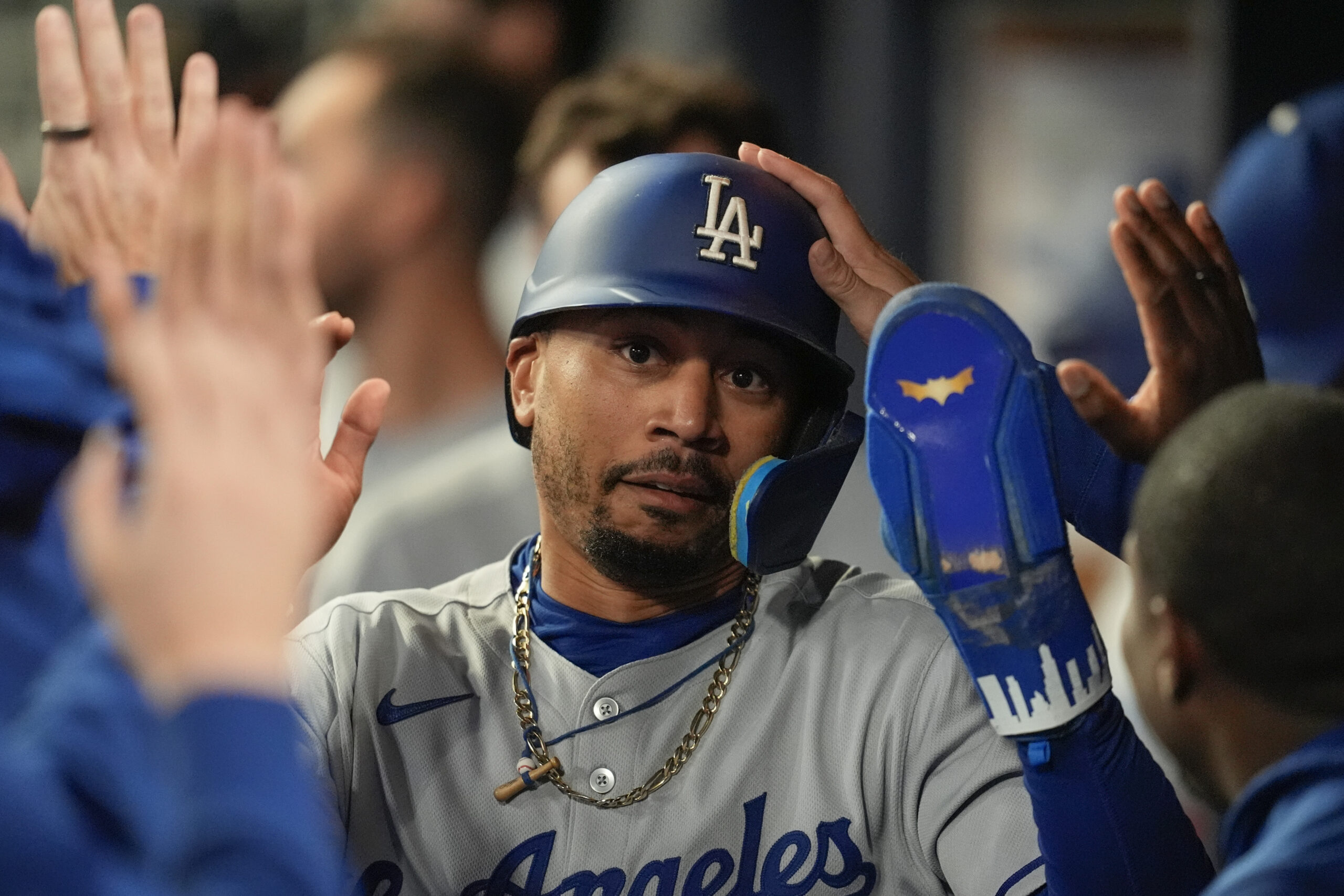 The Dodgers’ Mookie Betts celebrates in the dugout after scoring...