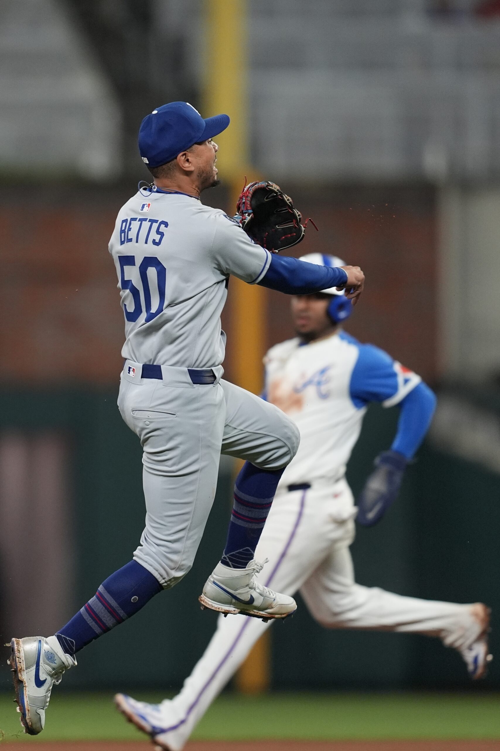 Dodgers shortstop Mookie Betts throws the ball to first base...