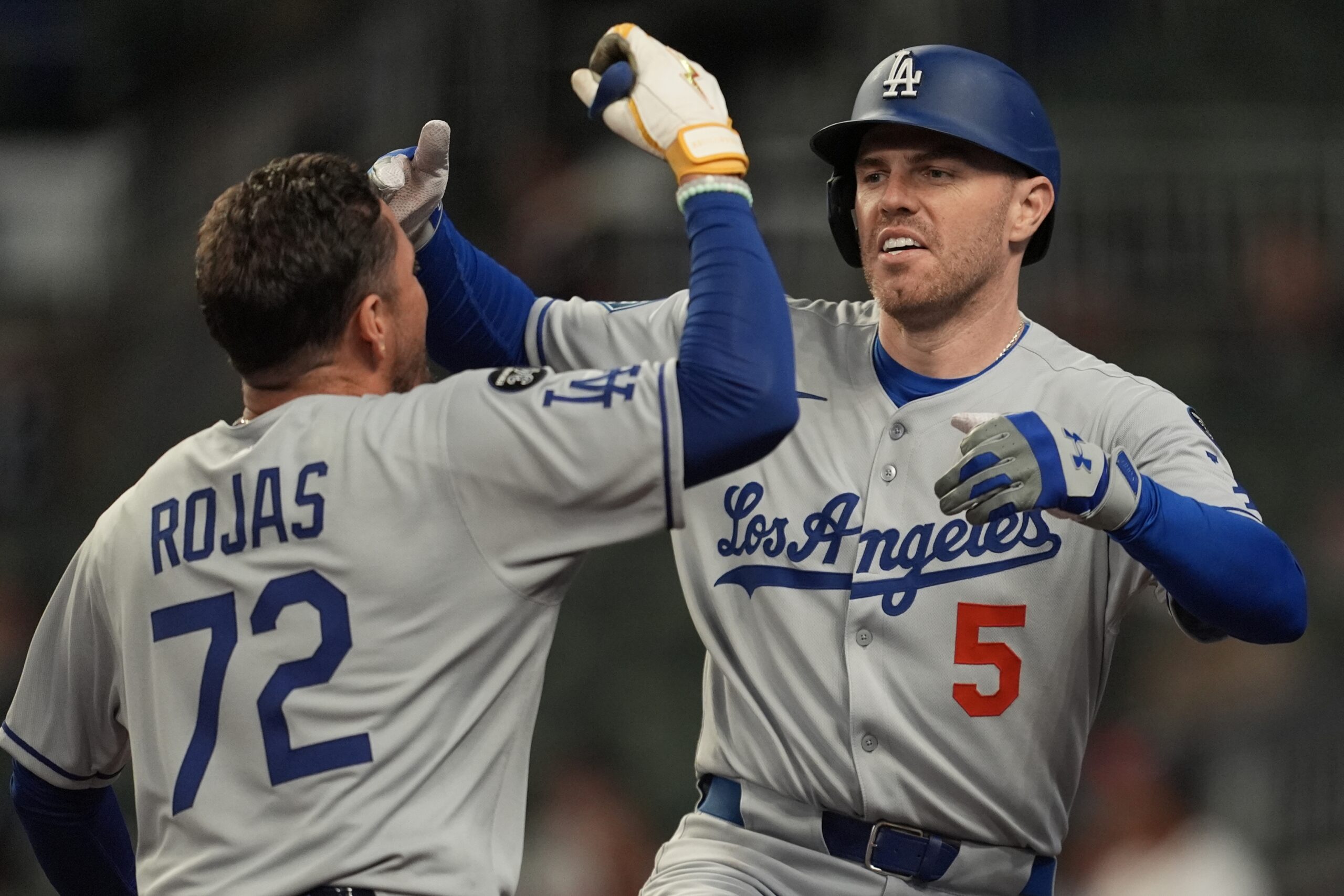 The Dodgers’ Freddie Freeman, right, celebrates with teammate Miguel Rojas...
