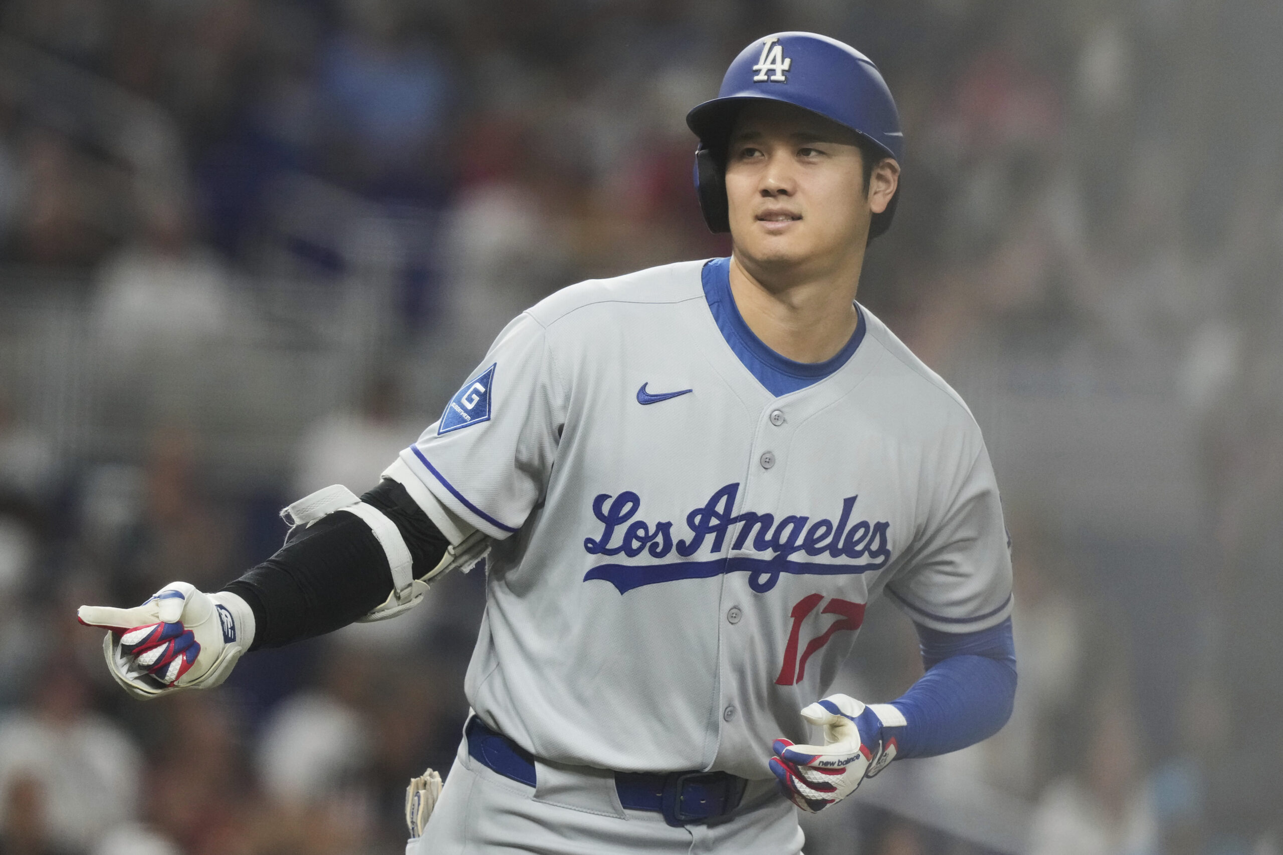 Dodgers star Shohei Ohtani gestures to his teammates in the...