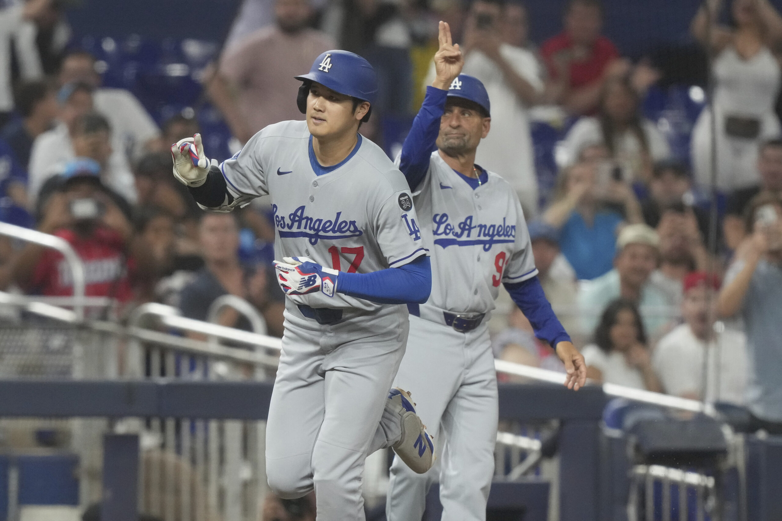 Dodgers star Shohei Ohtani, left, and third base coach Dino...