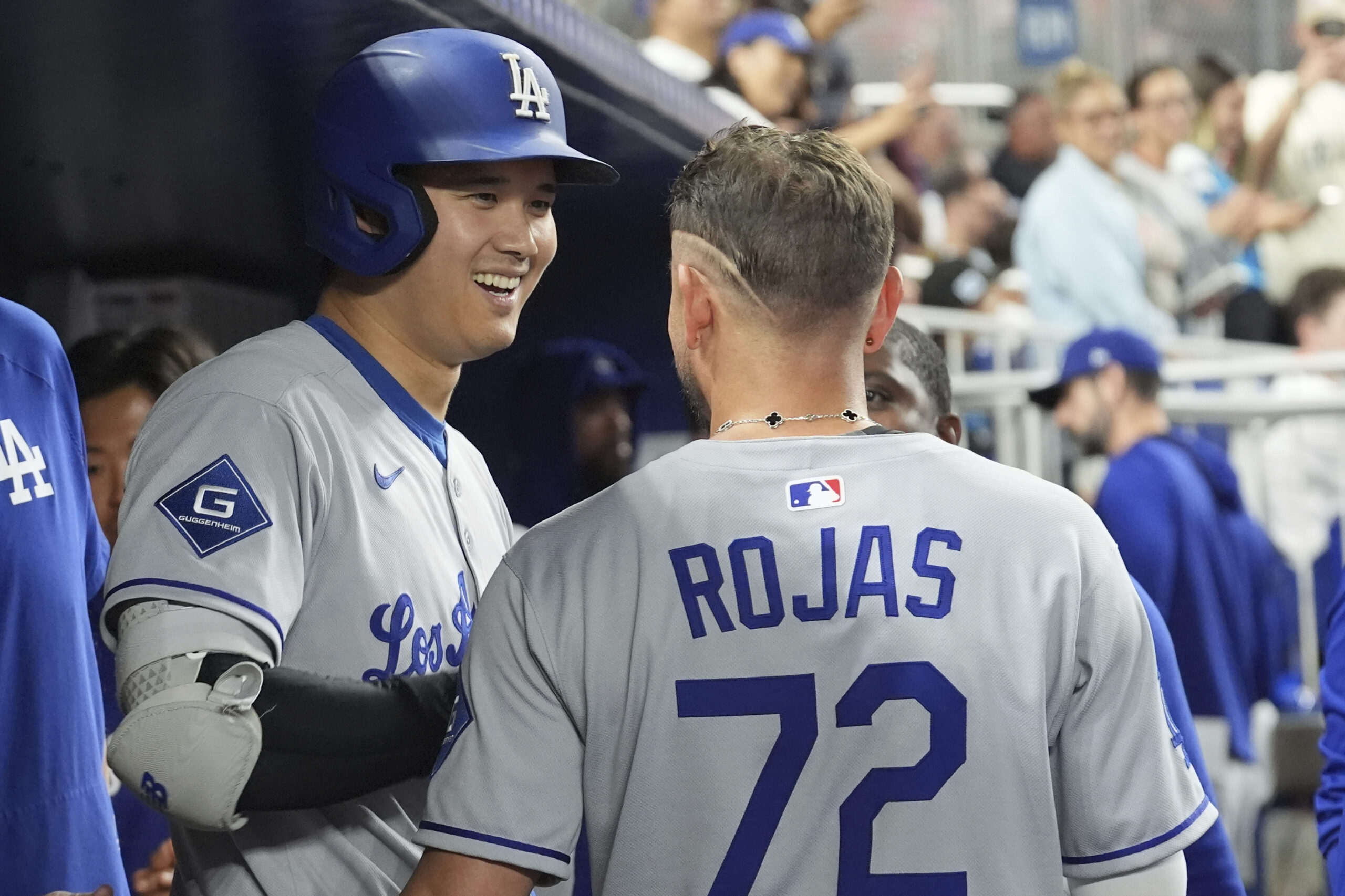 Dodgers star Shohei Ohtani smiles as he talks to teammate...
