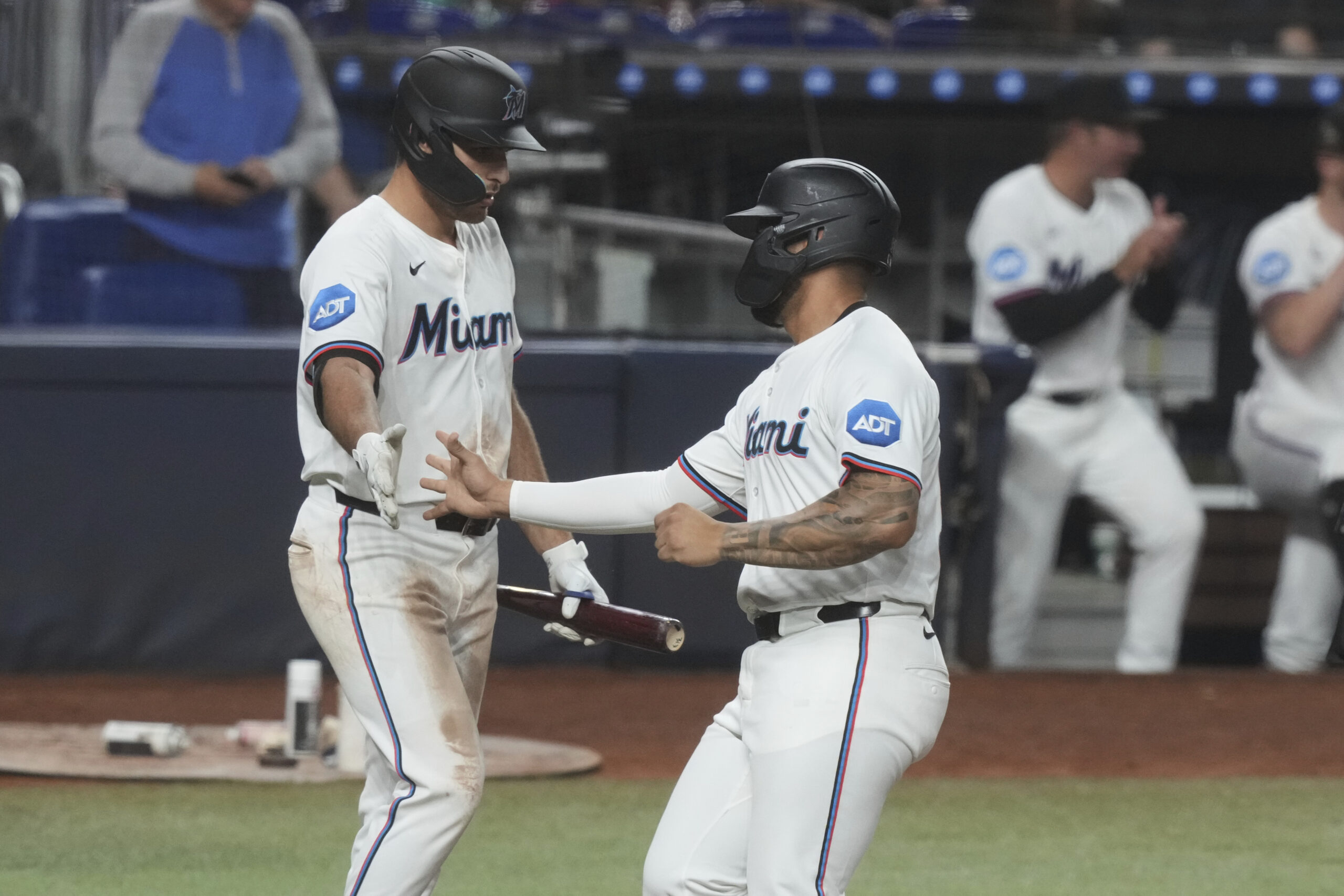 The Miami Marlins’ Agustín Ramírez, right, scores on a double...