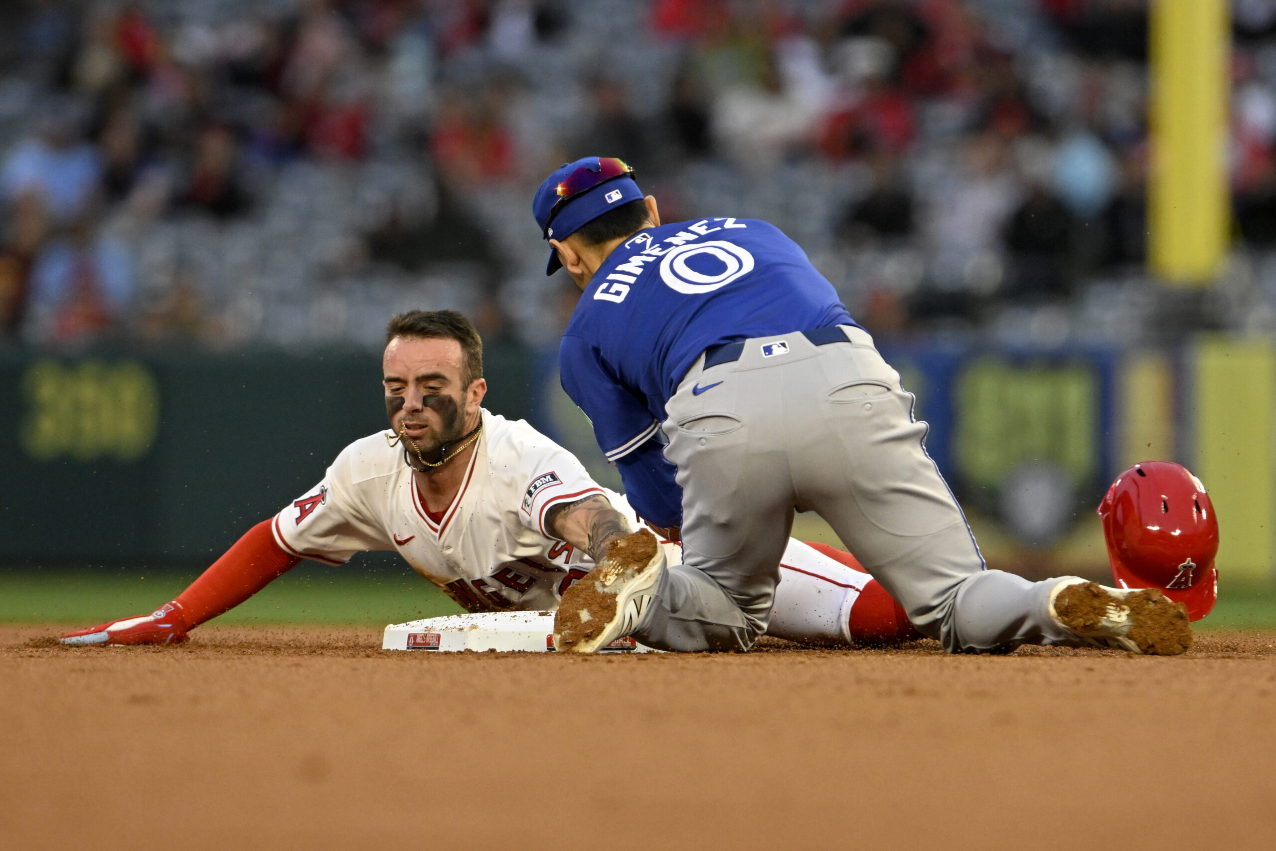 The Angels’ Zach Neto, left, steals second base beating the...