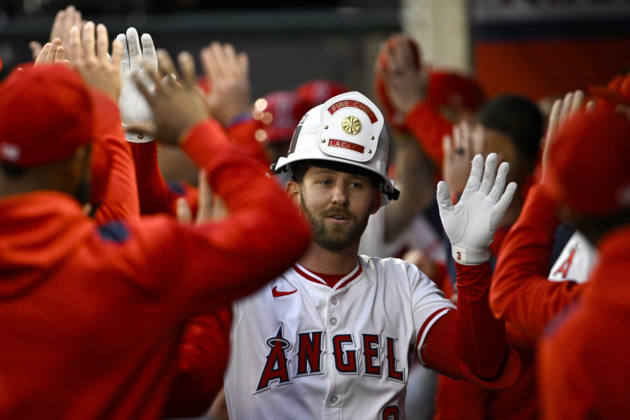 The Angels’ Taylor Ward celebrates with teammates in the dugout...