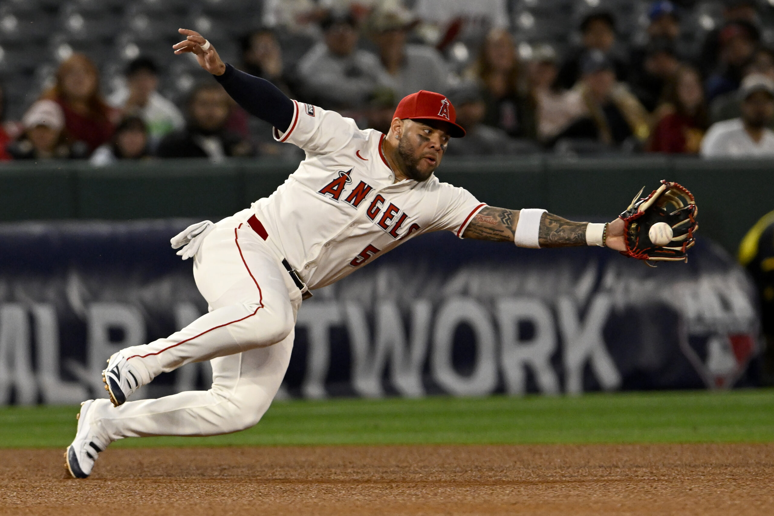 Angels third baseman Yoan Moncada can’t reach a bouncing ground...