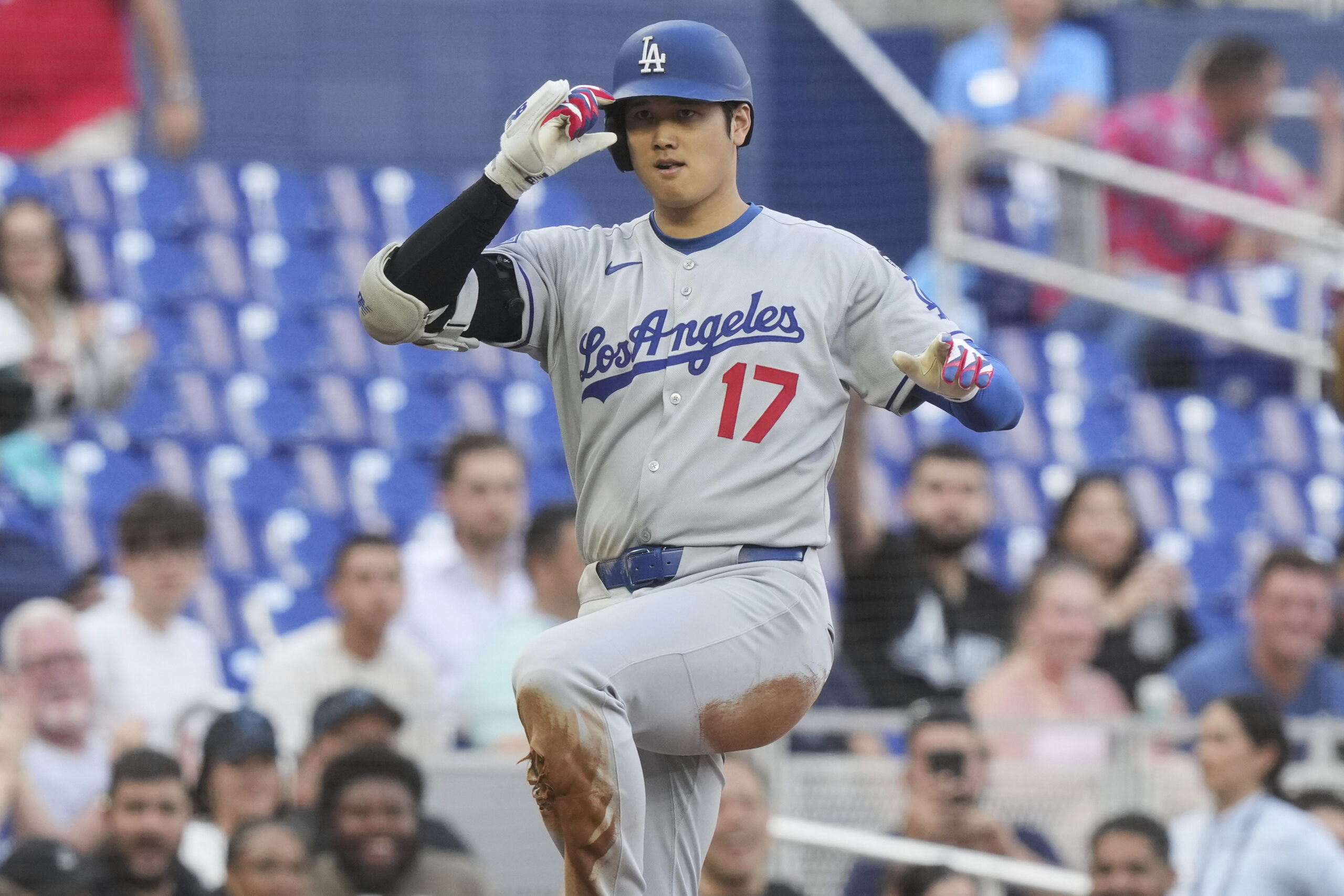 Dodgers star Shohei Ohtani gestures to teammates in the dugout...