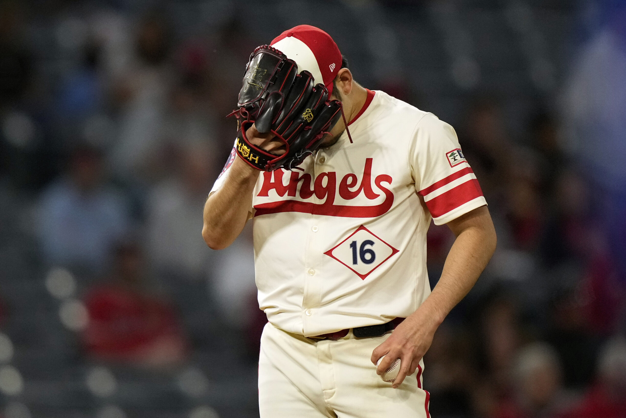 Angels starting pitcher Yusei Kikuchi puts his head in his...