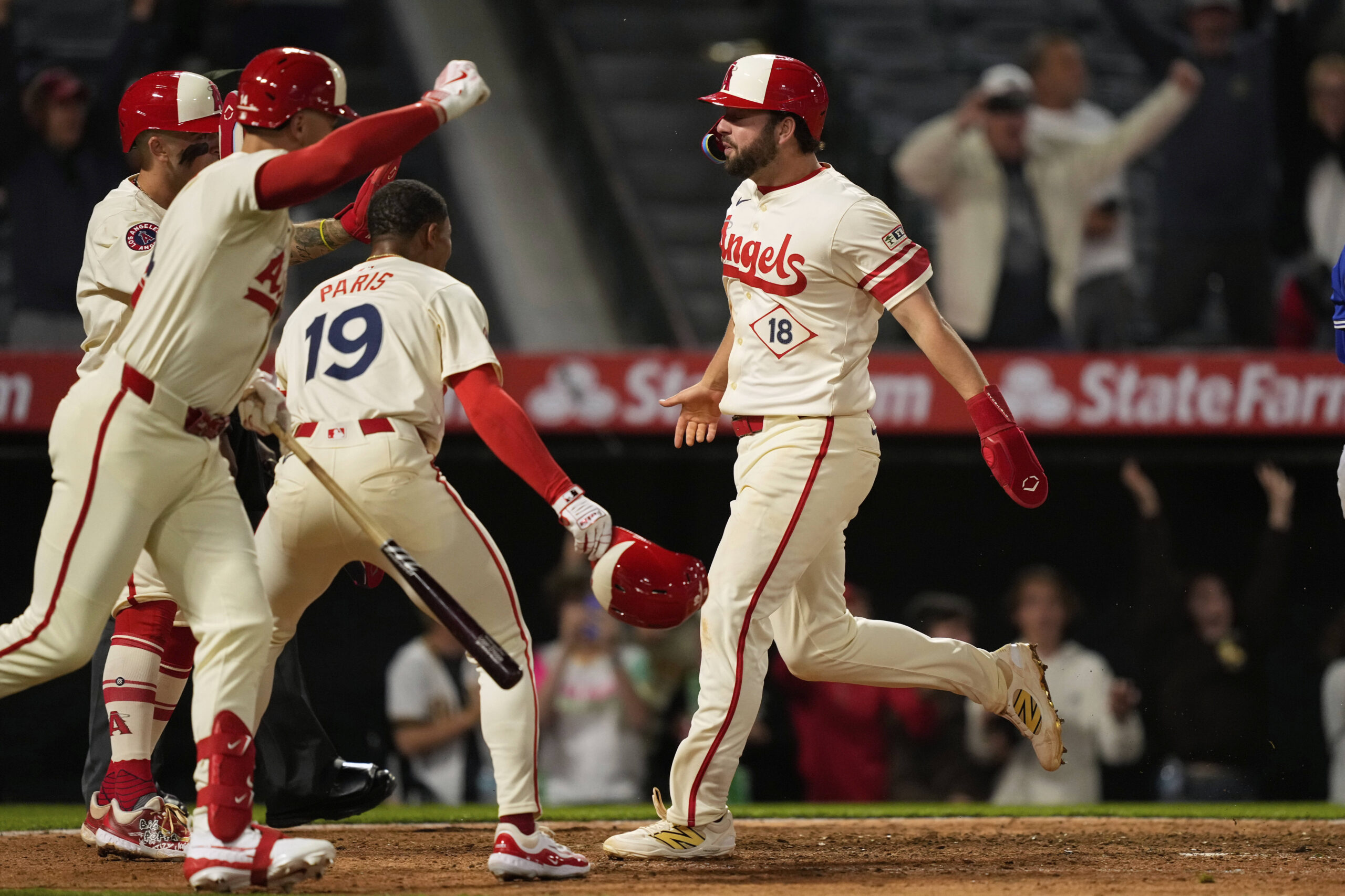 The Angels’ Nolan Schanuel, right, scores the winning run on...