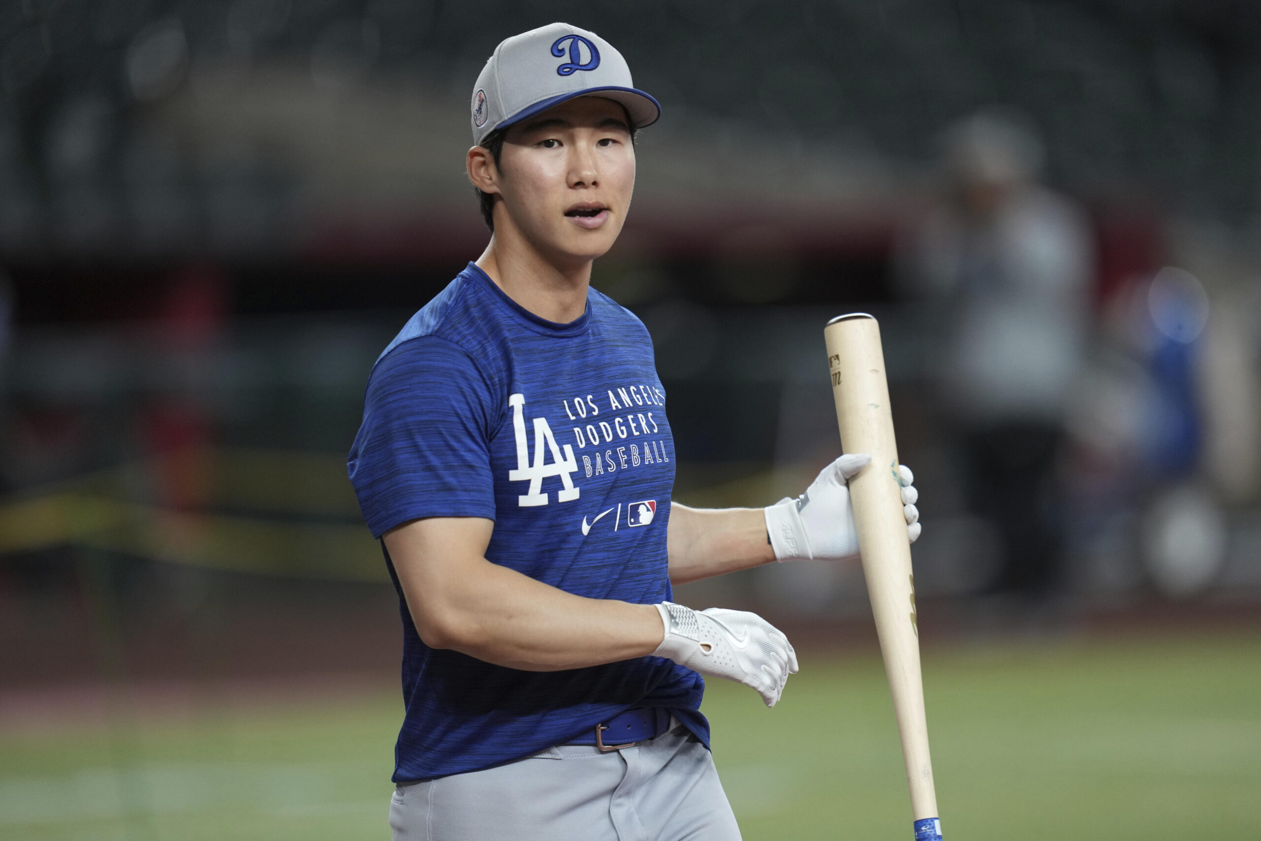 Dodgers infielder Hyeseong Kim gets loose prior to a game...