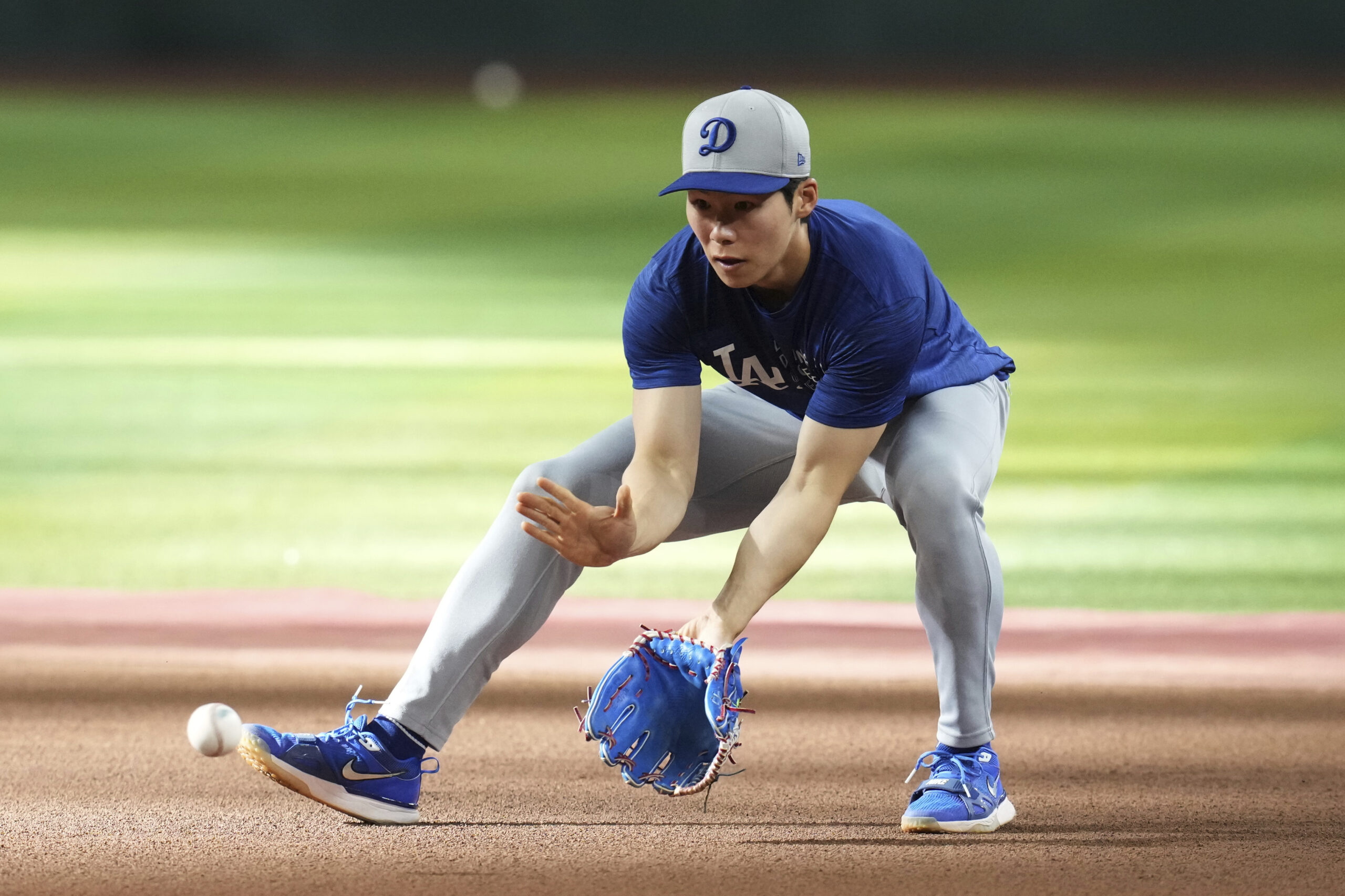 Dodgers infielder Hyeseong Kim warms up prior to a game...