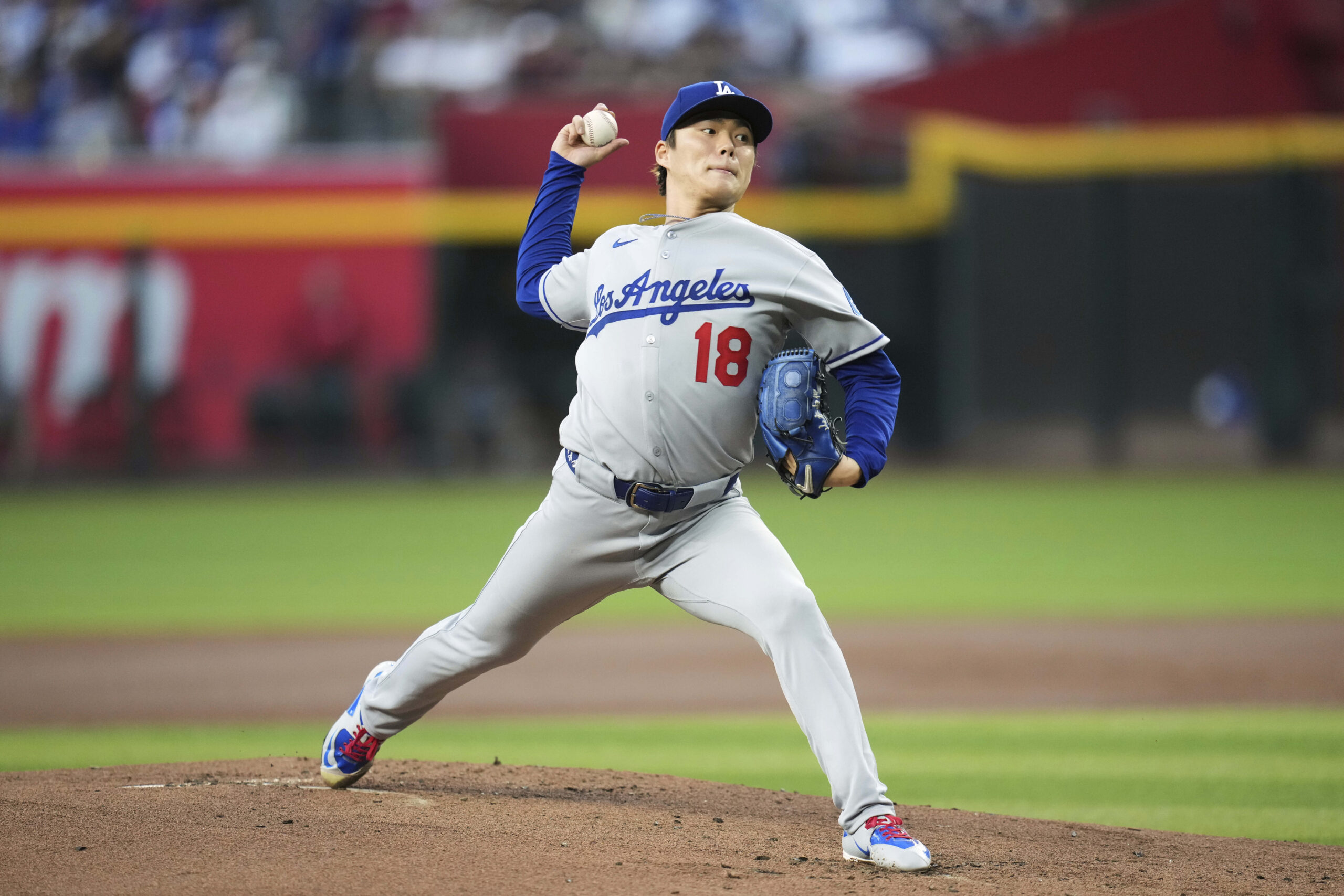 Dodgers starting pitcher Yoshinobu Yamamoto throws to the plate during...