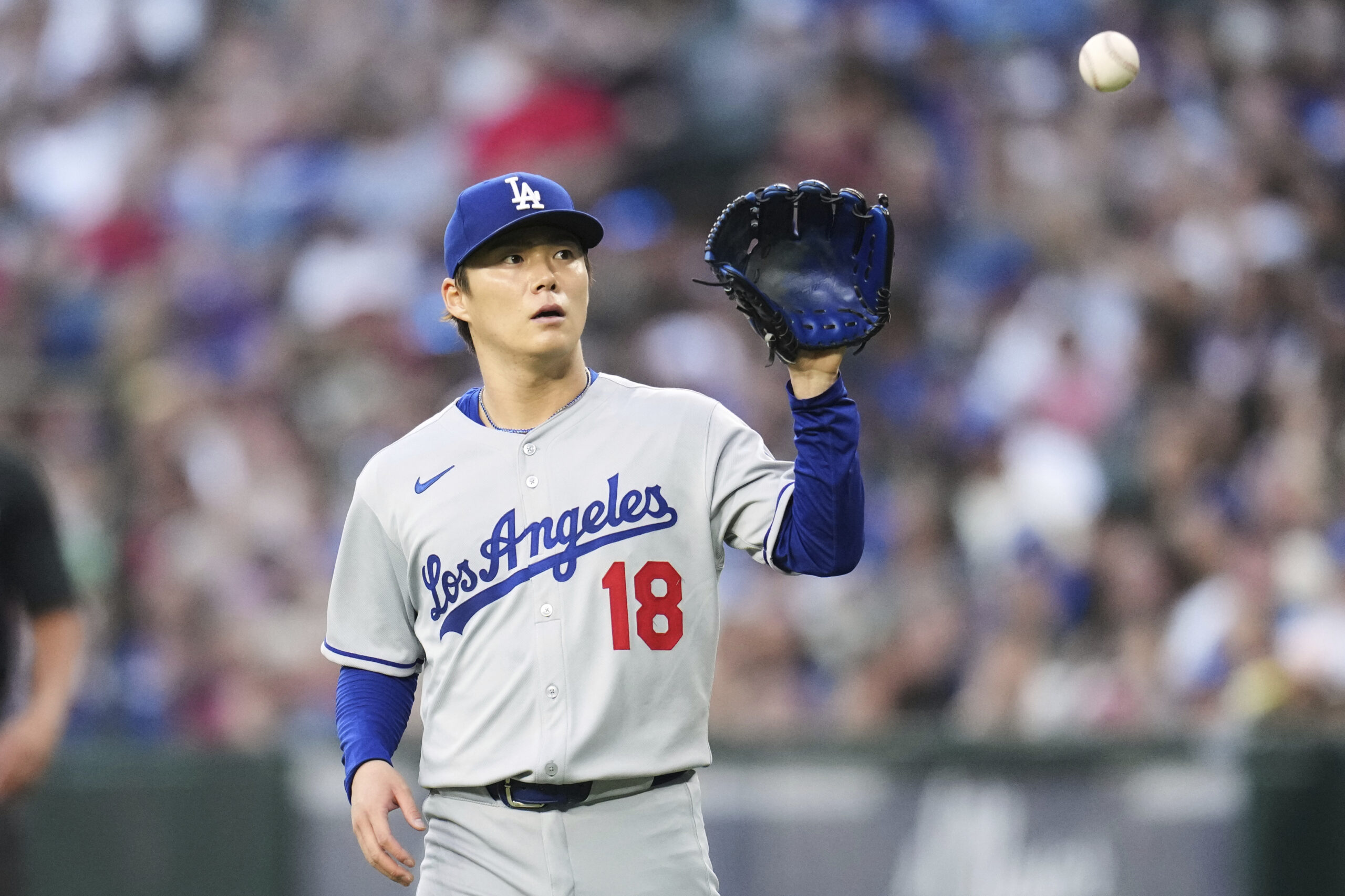 Dodgers starting pitcher Yoshinobu Yamamoto gets a new baseball during...
