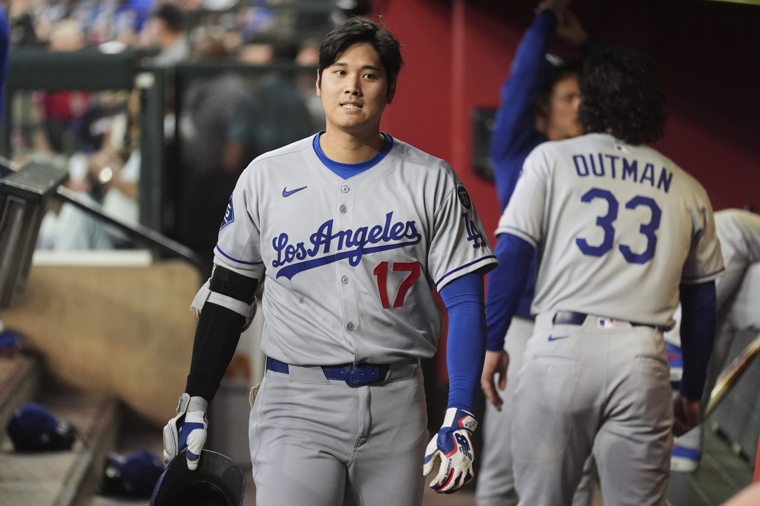 Dodgers designated hitter Shohei Ohtani walks back through the dugout...