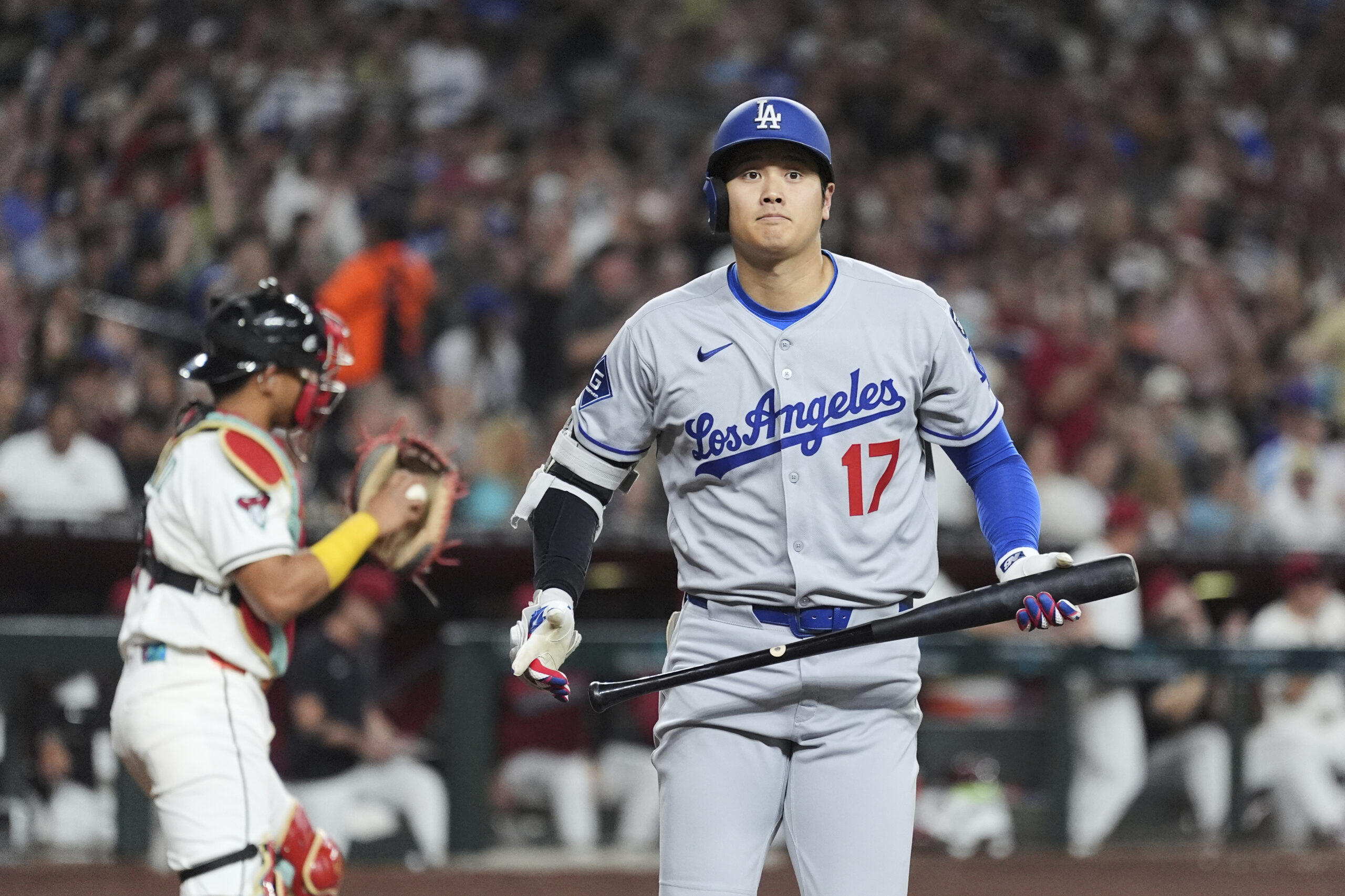 Dodgers star Shohei Ohtani walks back to the dugout after...
