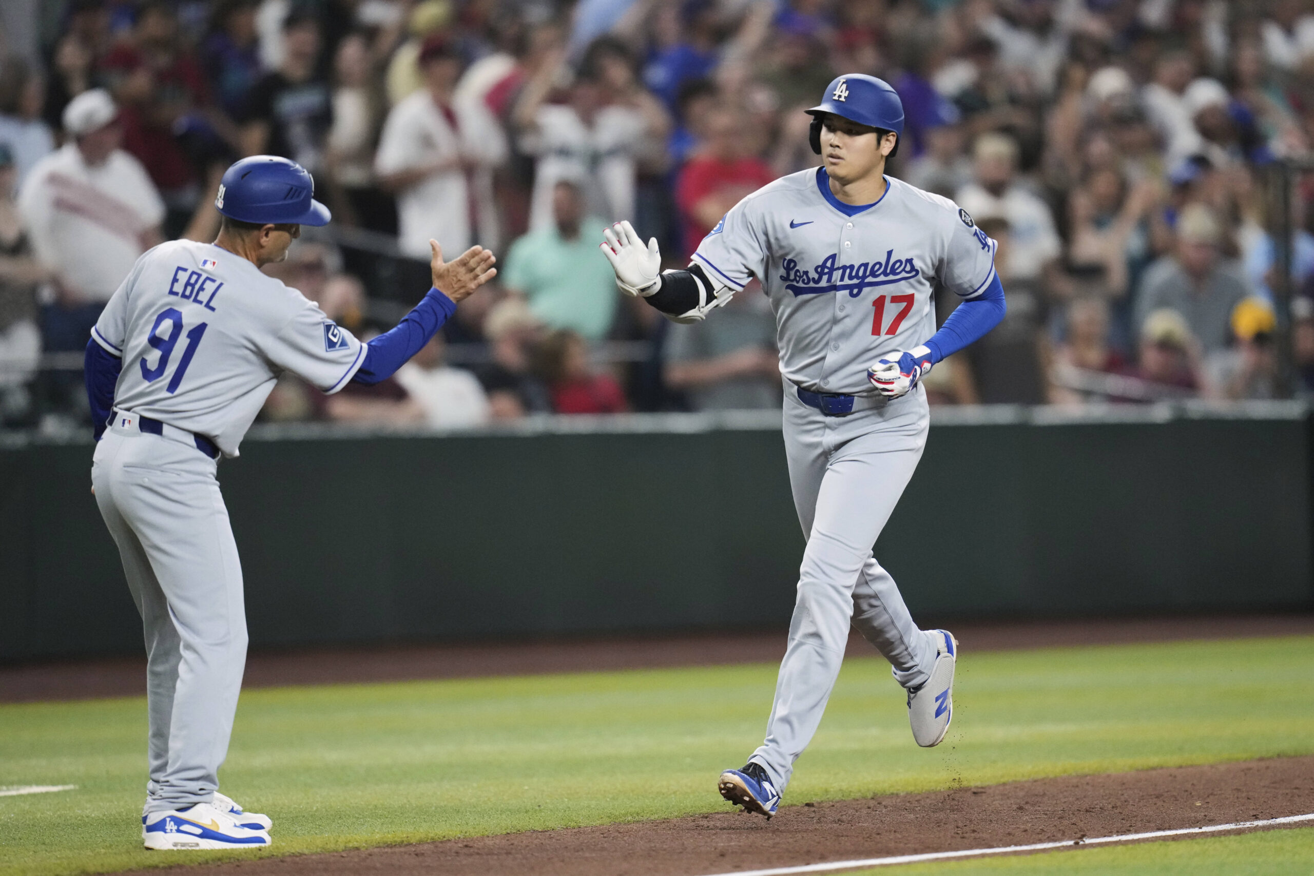Dodgers star Shohei Ohtani, right, celebrates his home run with...