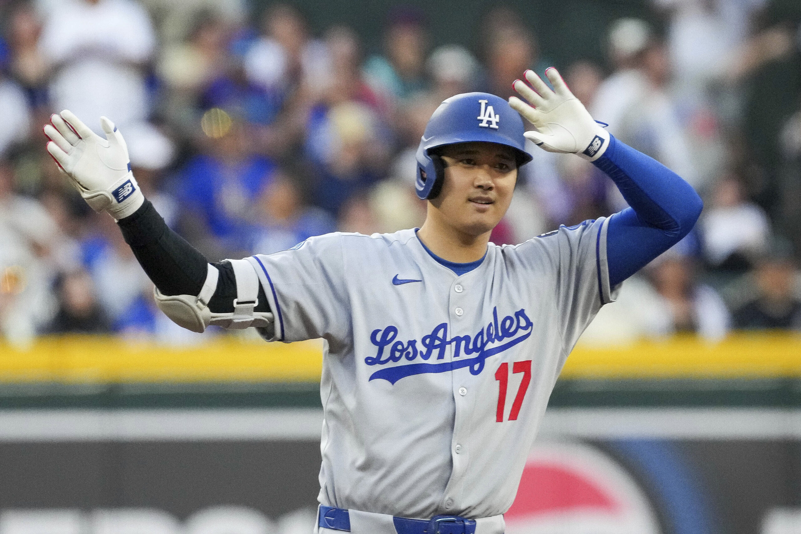 Dodgers star Shohei Ohtani gestures after hitting a double against...