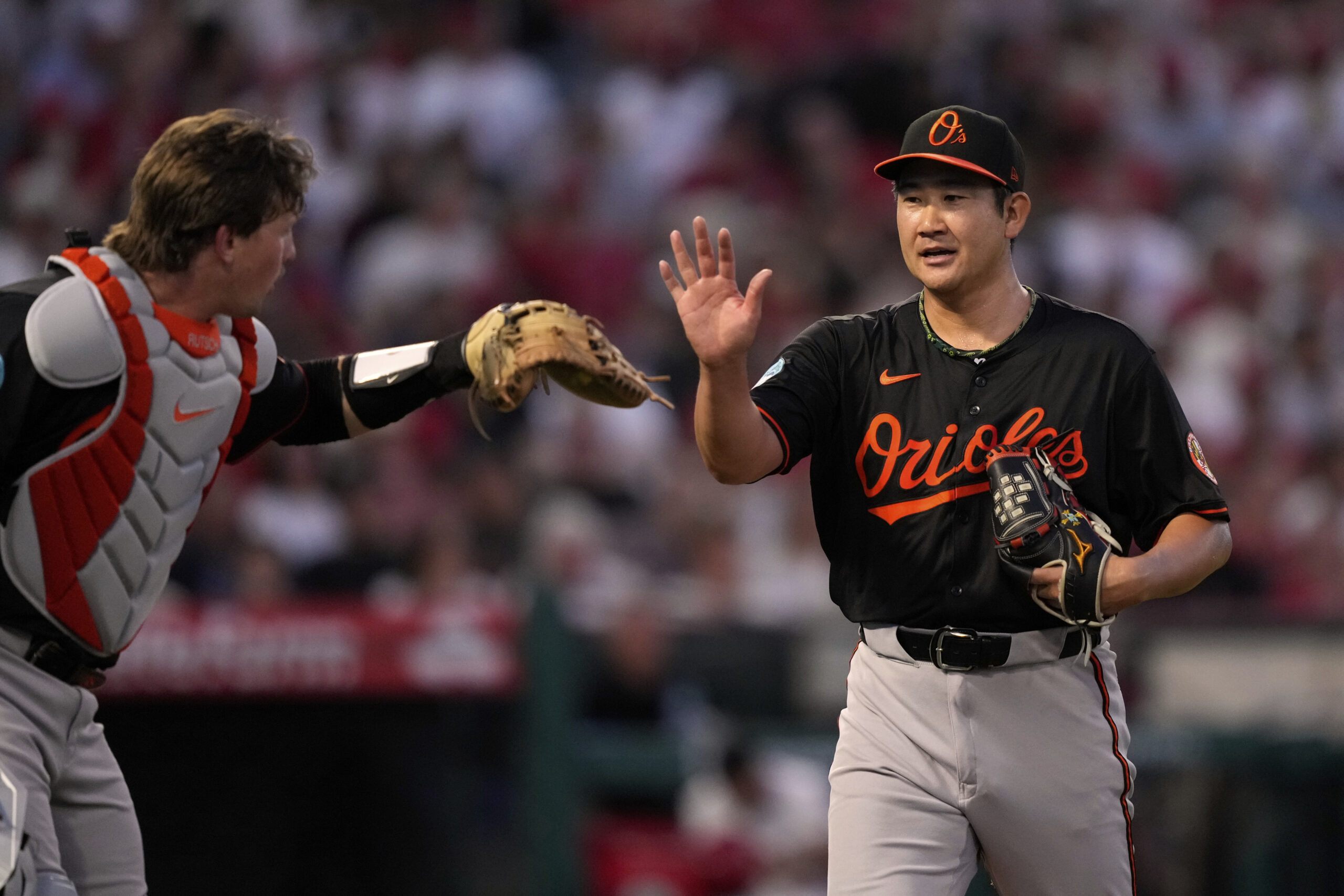 Baltimore Orioles catcher Adley Rutschman, left, and starting pitcher Tomoyuki...