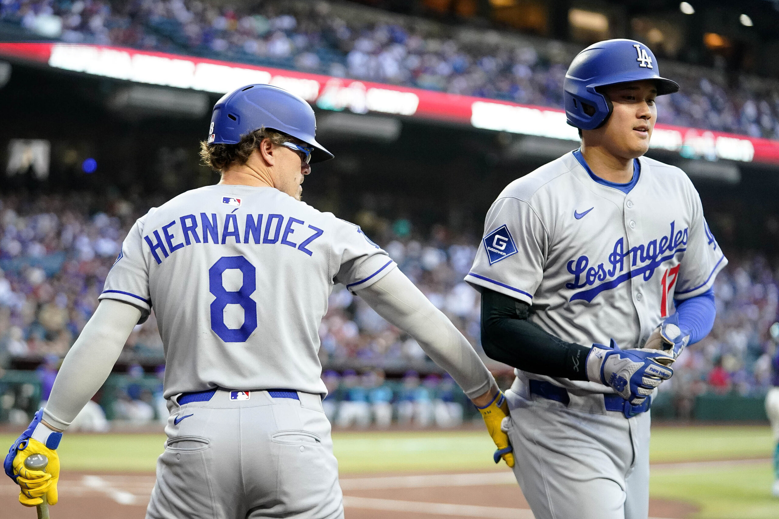 Dodgers star Shohei Ohtani, right, gets a pat from teammate...