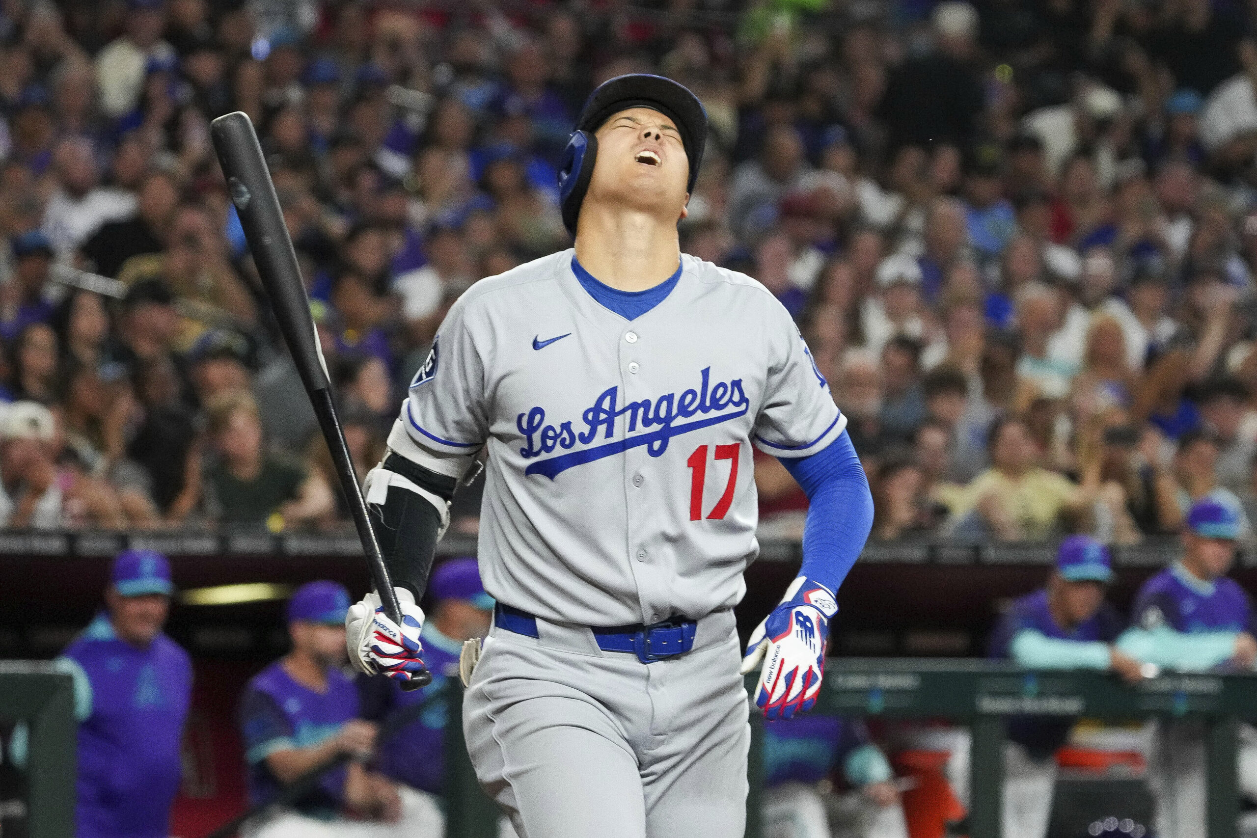 Dodgers star Shohei Ohtani reacts after a foul ball hit...