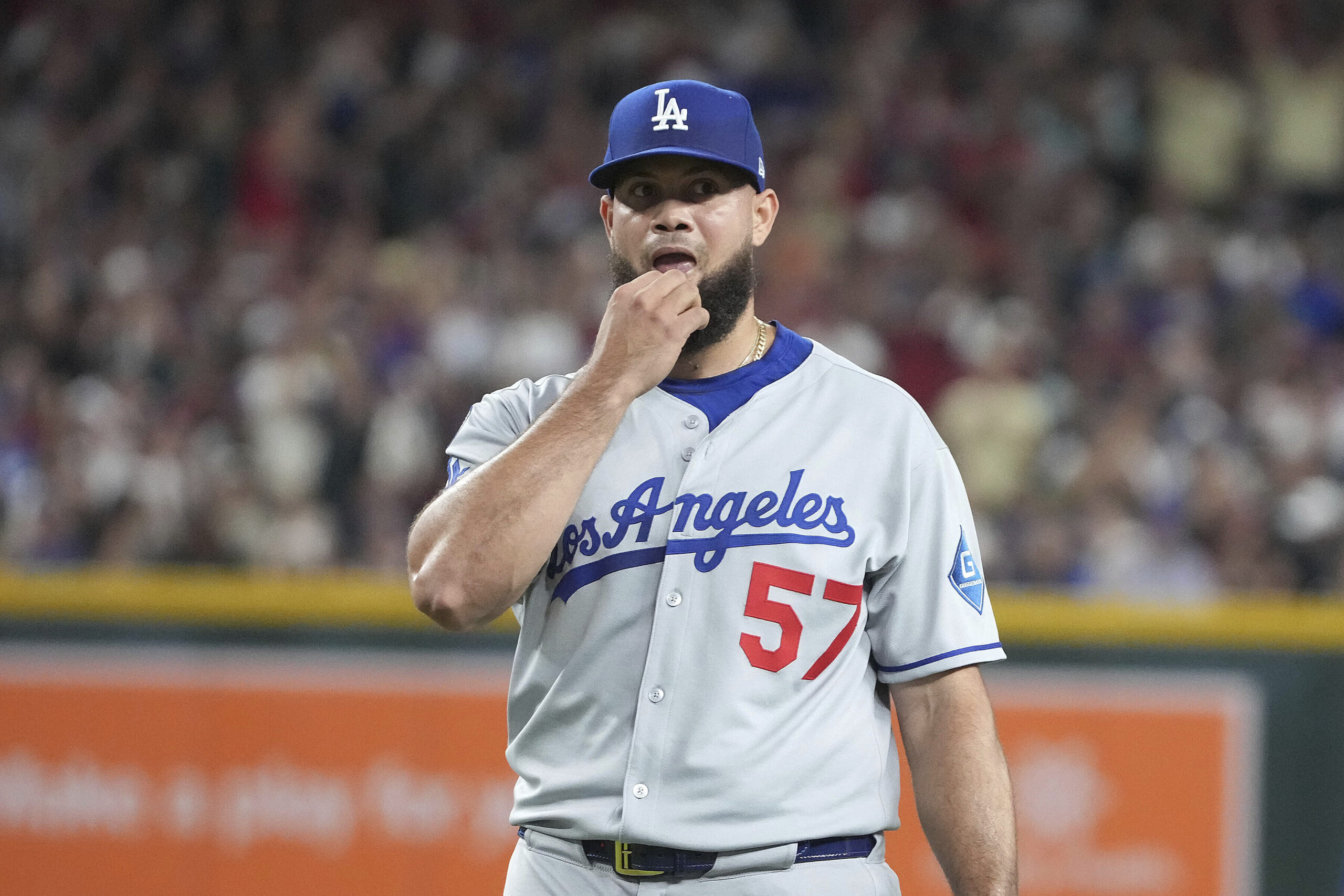 Dodgers relief pitcher Luis García reacts after walking in a...