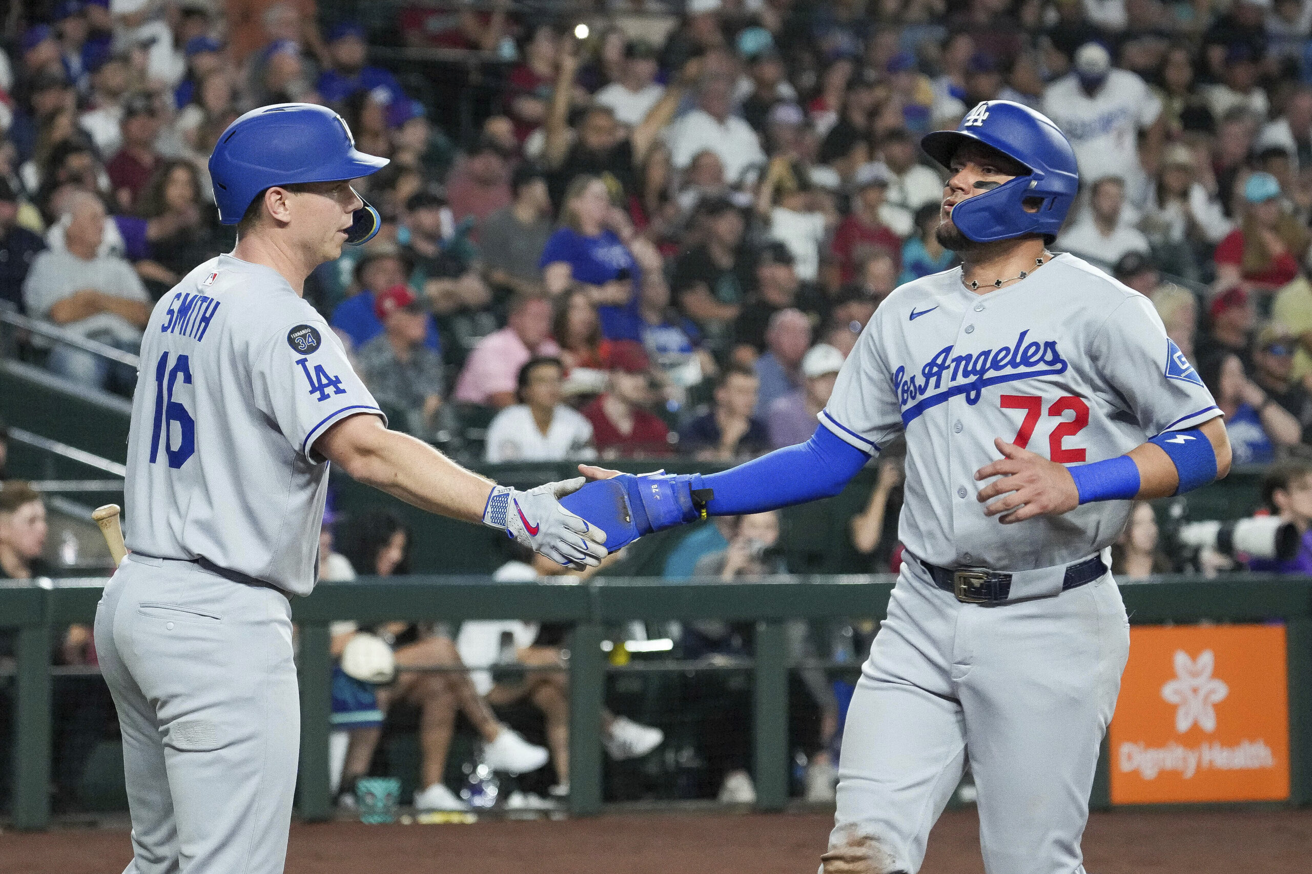 The Dodgers’ Miguel Rojas, right, is greeted at home by...
