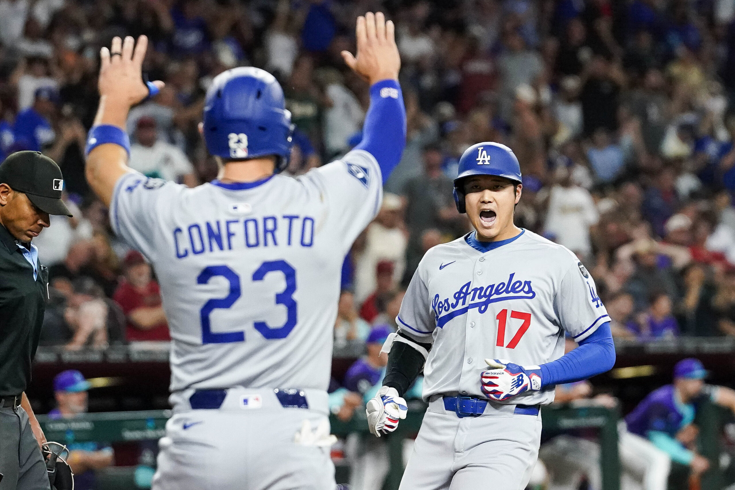 Dodgers star Shohei Ohtani, right, celebrates as teammate Michael Conforto...