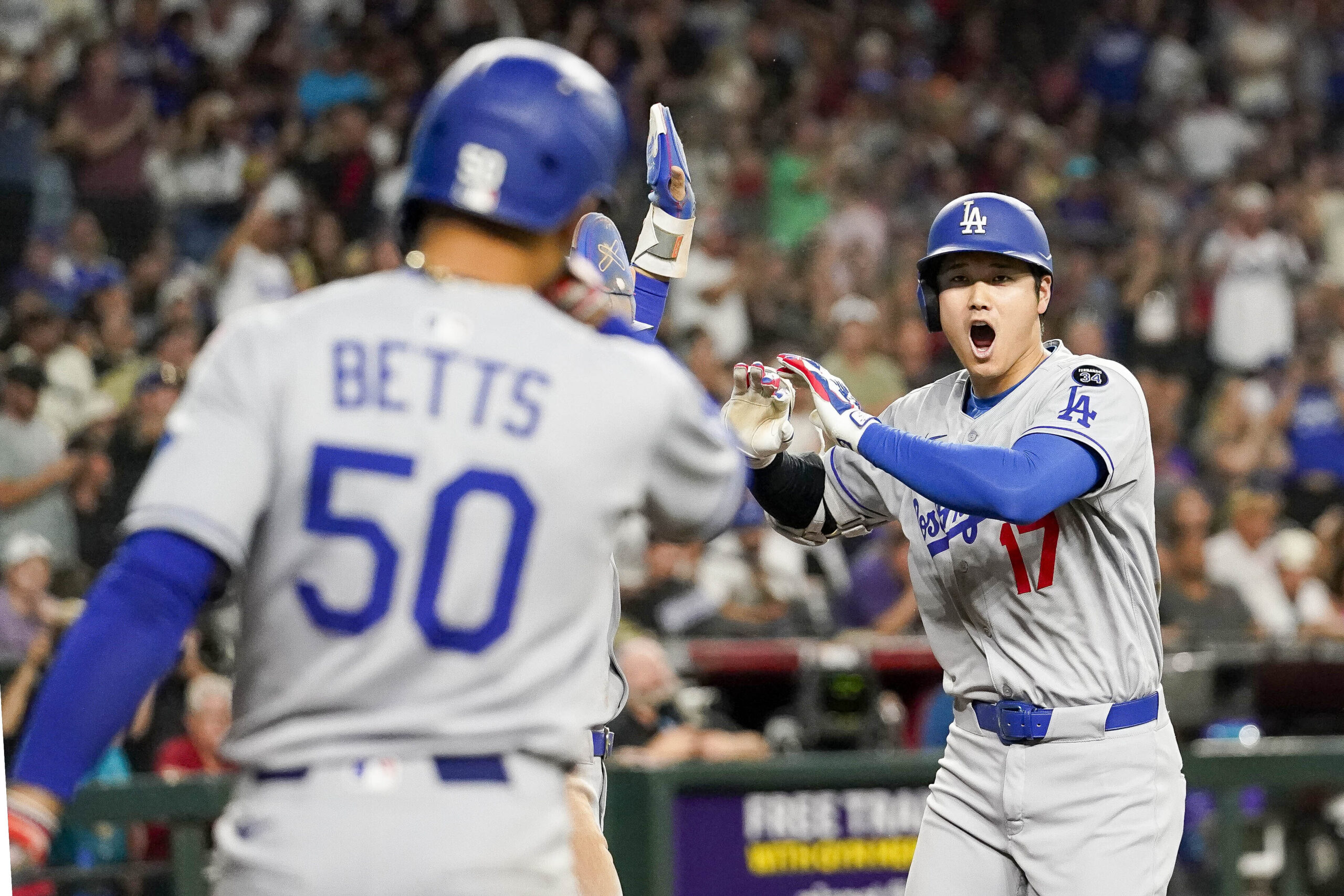 Dodgers star Shohei Ohtani, right, celebrates as teammate Mookie Betts...