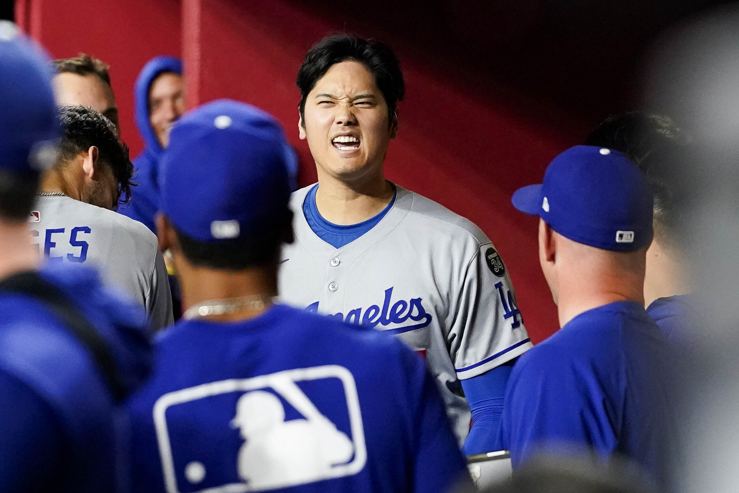 Dodgers star Shohei Ohtani celebrates in the dugout after hitting...