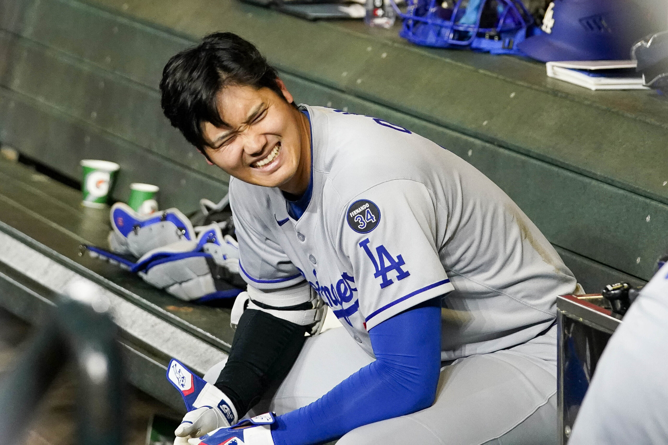 Dodgers star Shohei Ohtani smiles in the dugout after hitting...